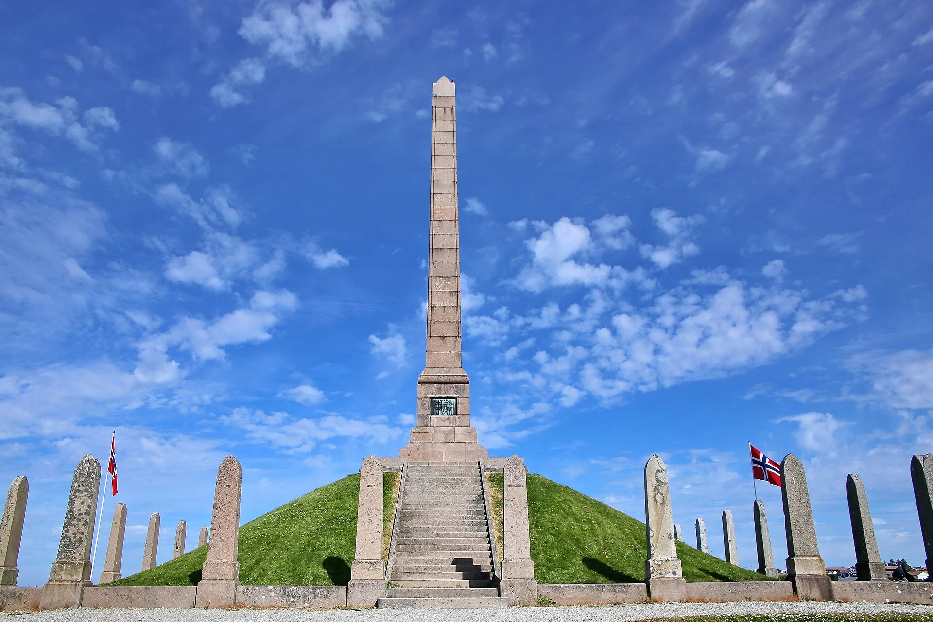 Der Granitobelisk auf dem Grabhügel Haraldshaugen in Haugesund, umgeben von Steinstelen.