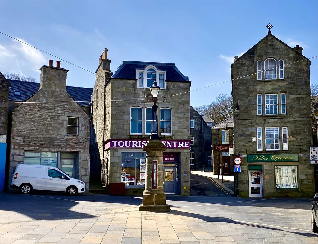 Das Market Cross an der Commercial Street in Lerwick vor dem Tourist Centre bei Sonnenschein.