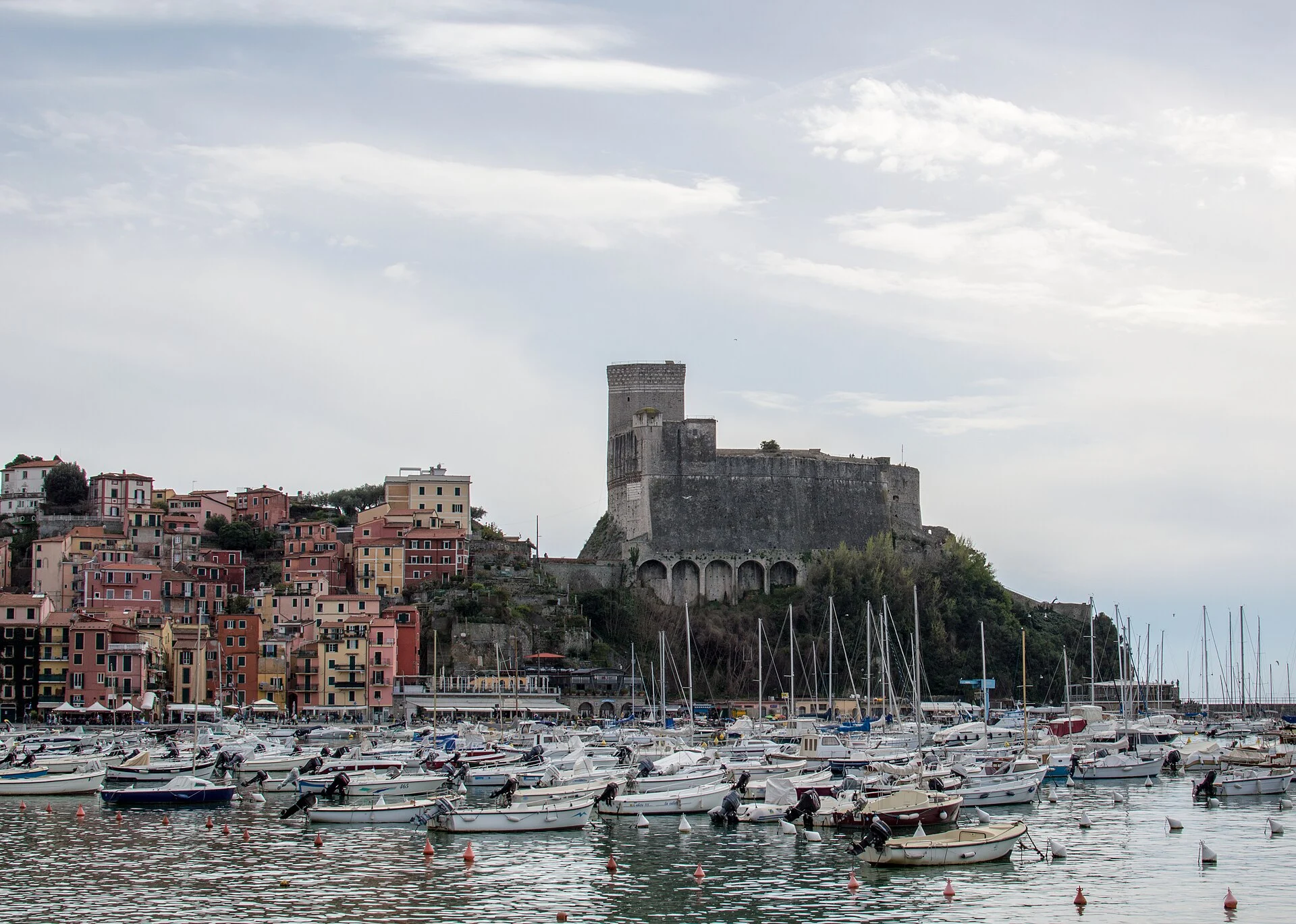 Die Burg Castello di Lerici über dem Hafen mit Booten und bunten Altstadthäusern.