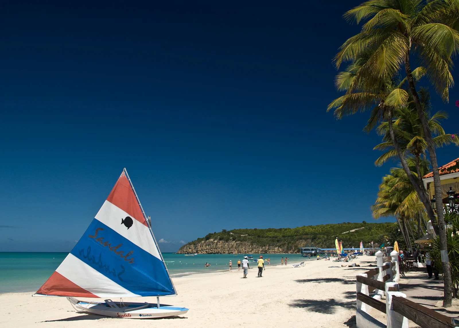 Der Strand der Dickenson Bay auf Antigua mit einem Segelboot