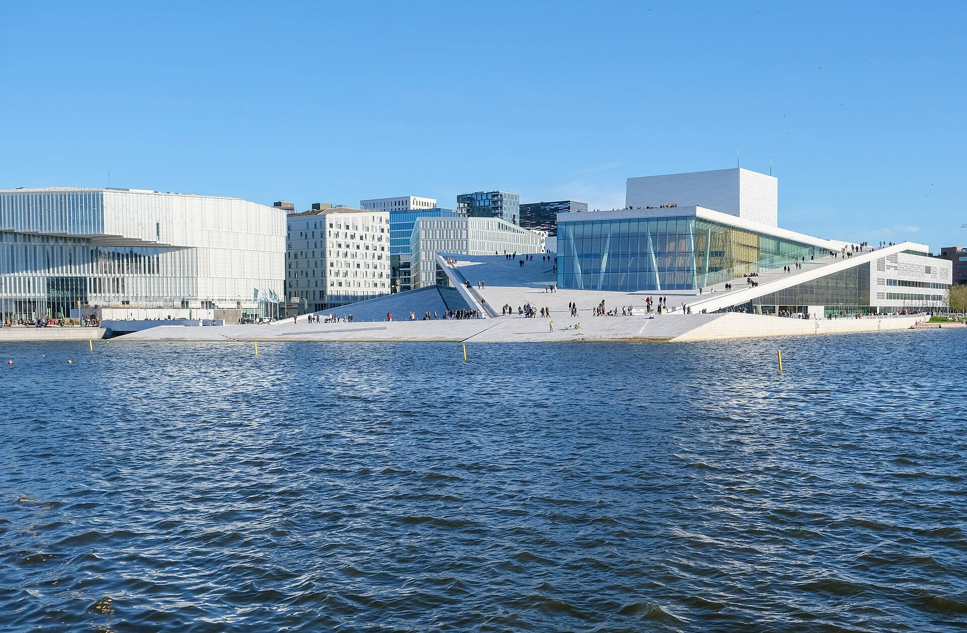 Das Opernhaus Oslo mit seinem begehbaren, schräg ansteigenden Marmordach vom Wasser des Oslofjords aus gesehen.