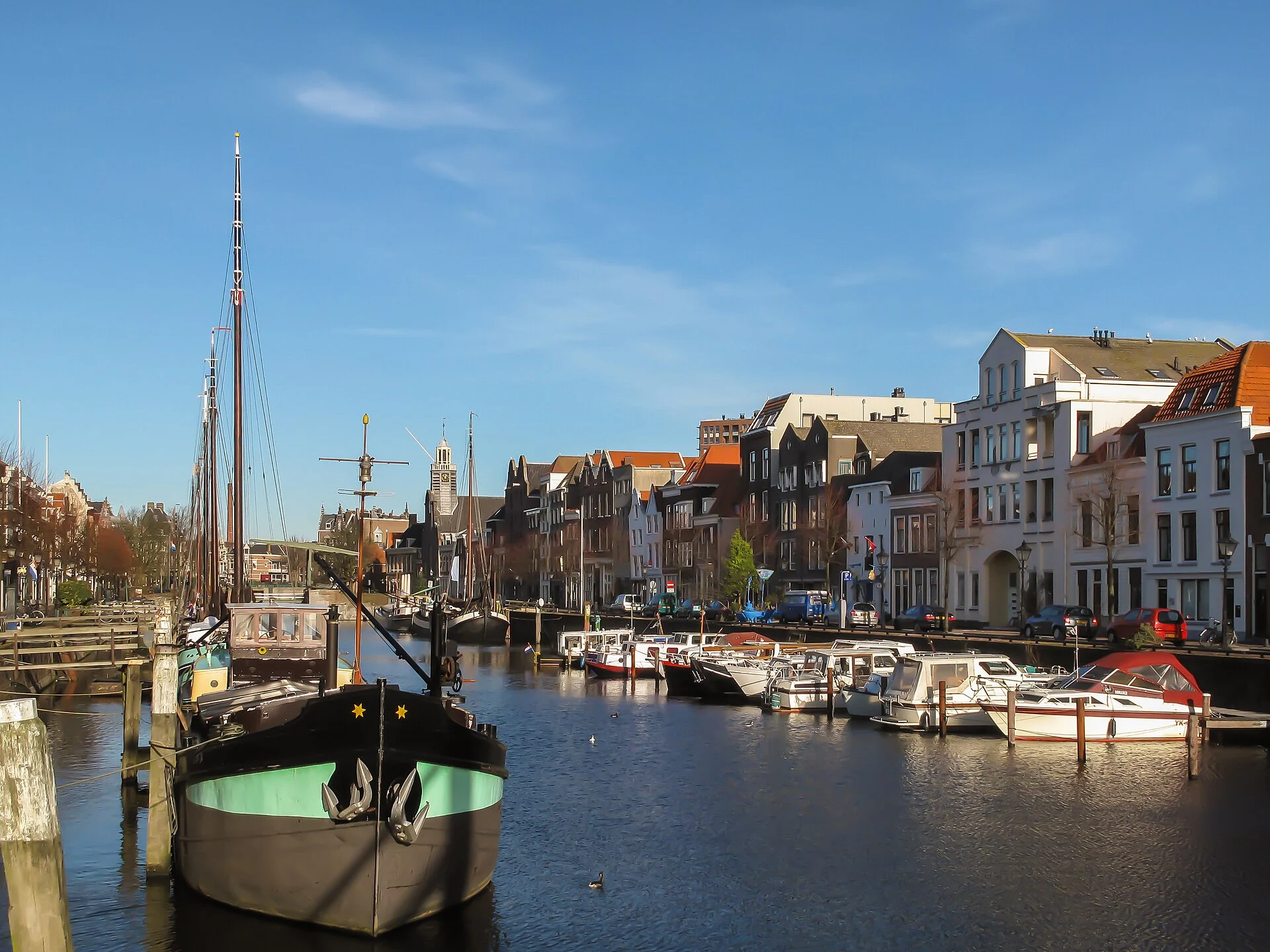 Blick über das historische Hafenbecken von Delfshaven in Rotterdam mit alten Segelschiffen, Booten und Grachtenhäusern.