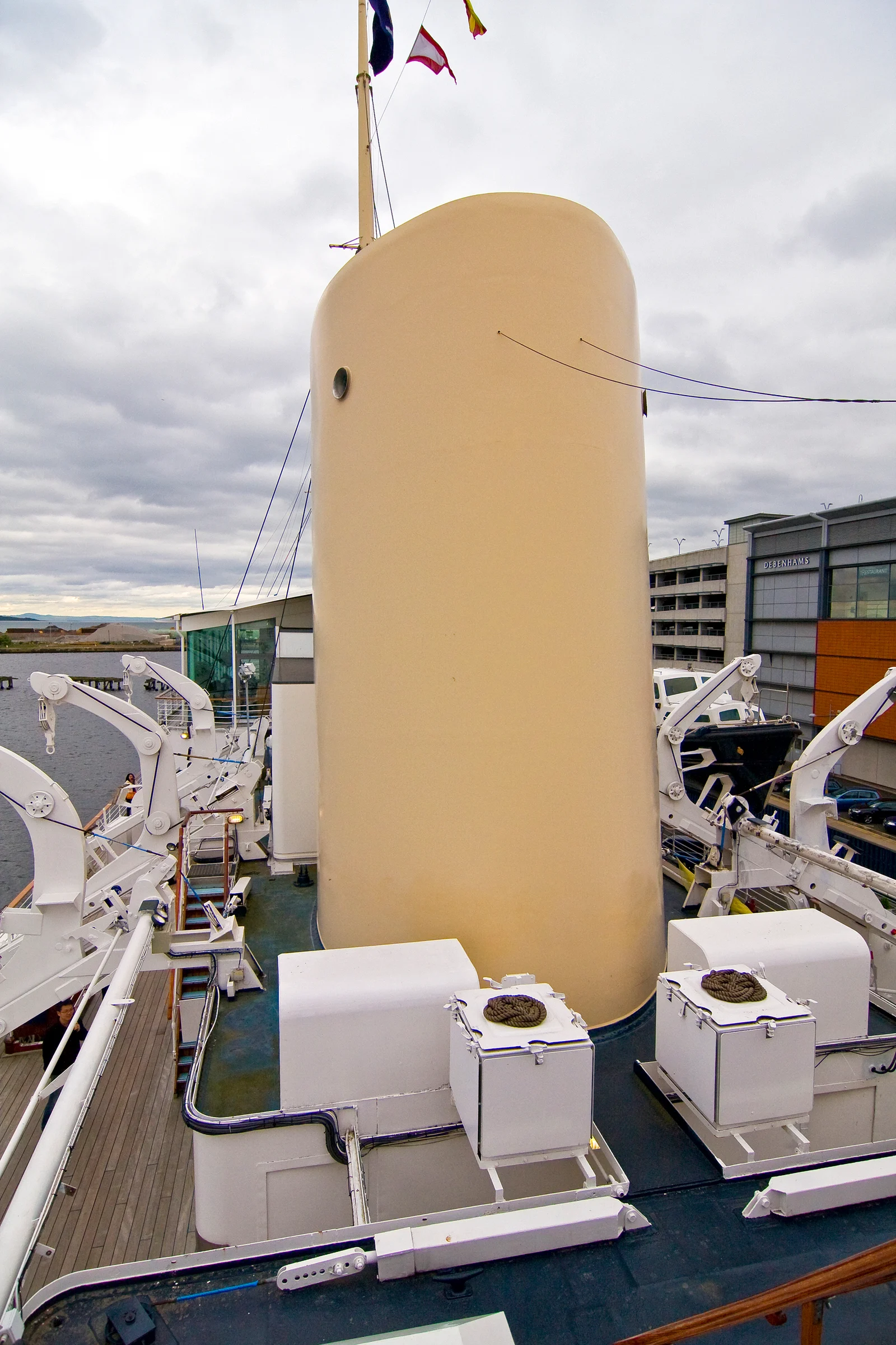 Schornstein und Oberdeck der Royal Yacht Britannia mit dem angrenzenden Ocean Terminal in Leith, Edinburgh.