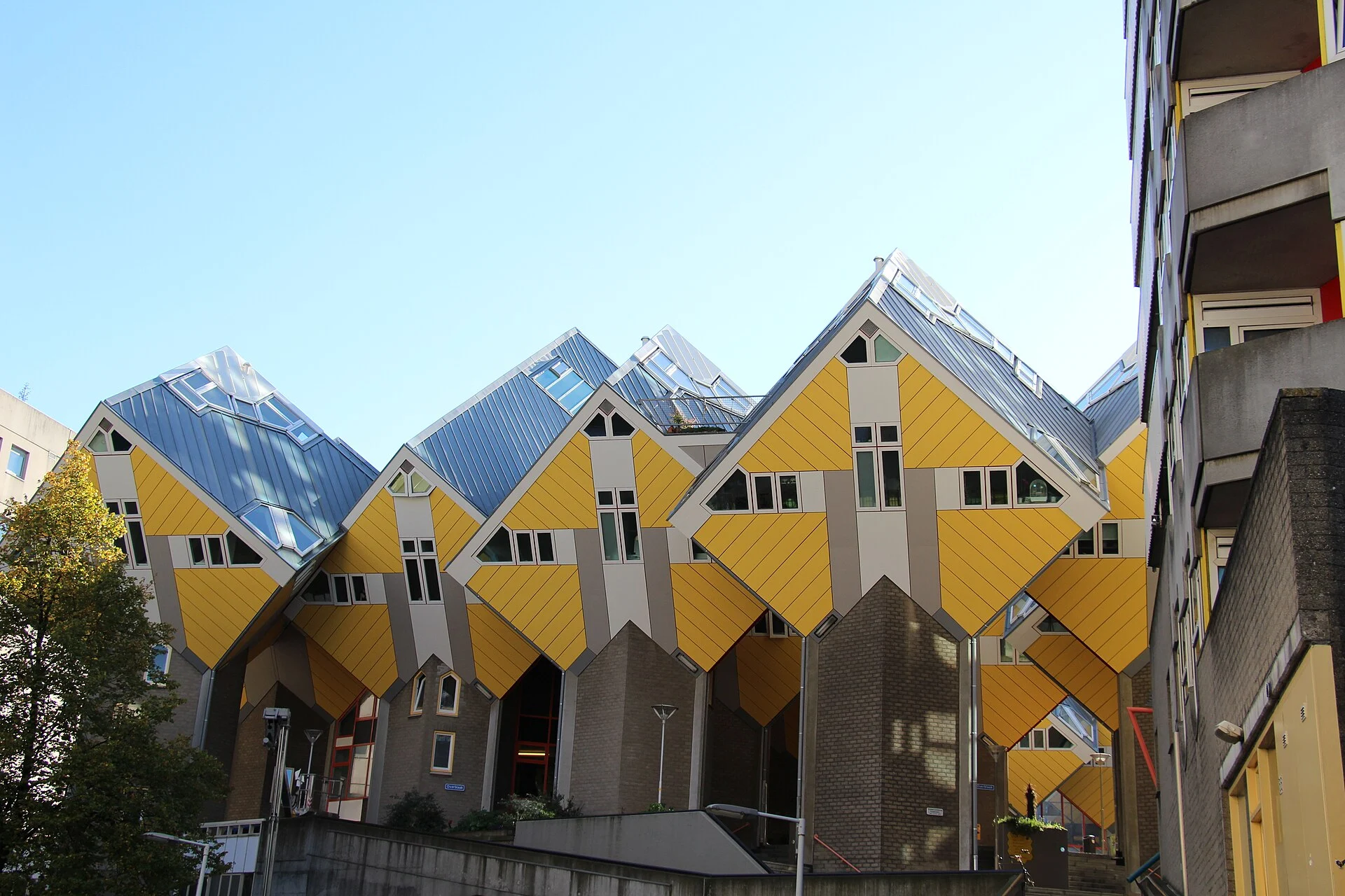 Gruppe der gelben, auf die Ecke gestellten Kubushäuser von Piet Blom in Rotterdam vom Innenhof aus gesehen.