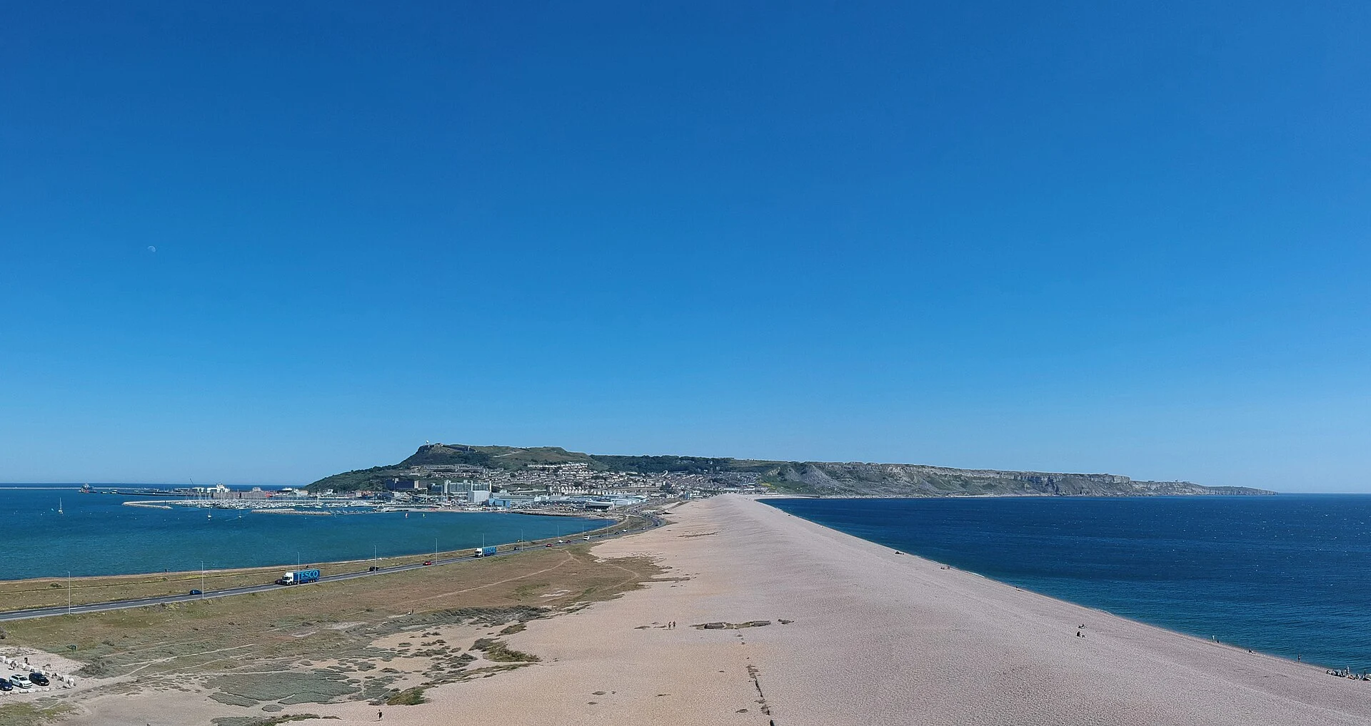 Blick über Chesil Beach auf die Isle of Portland mit Hafen und Kliffküste, Dorset.