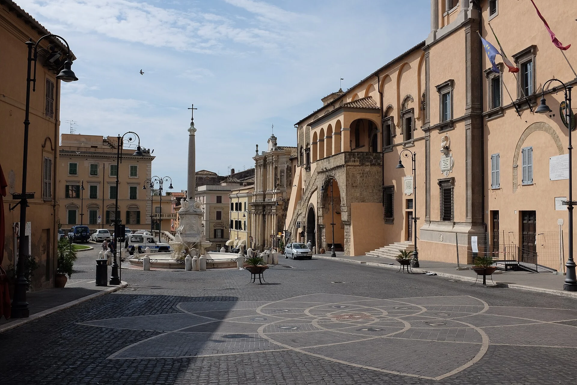 Zentraler Platz von Tarquinia mit Brunnen, Obelisk und dem Palazzo Comunale rechts.