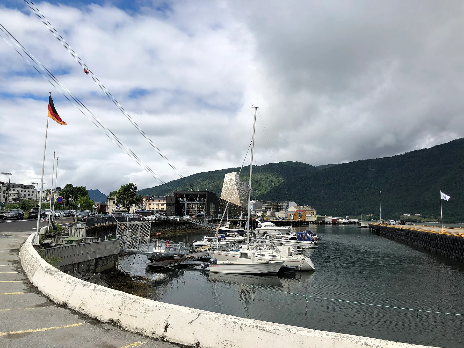 Talstation der Romsdalsgondolen mit gespannten Tragseilen und Gondel über dem Bootshafen von Åndalsnes, Norwegen.