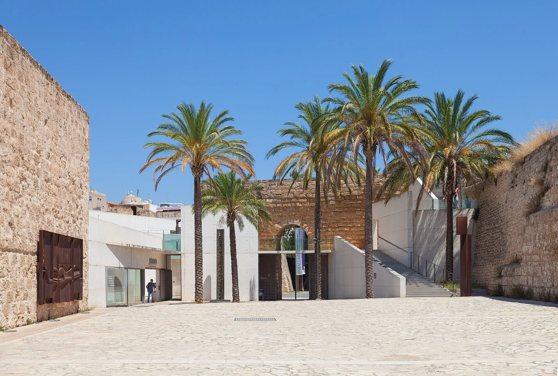Vorplatz des Museums Es Baluard in Palma de Mallorca mit Bastionsmauern, Palmen und modernem Betonbau.