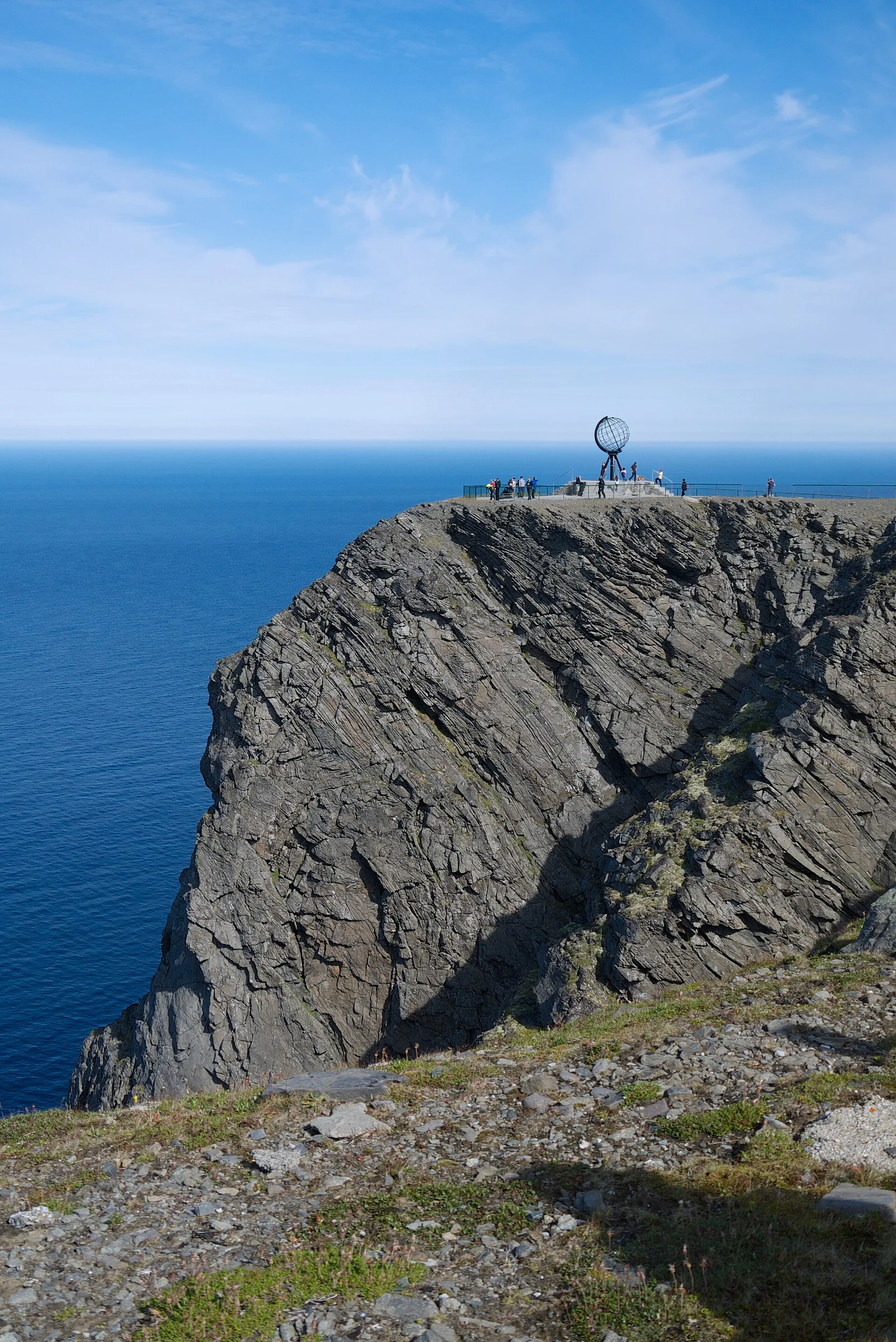 Die rund 300 Meter hohe Nordkap-Klippe mit dem Globus-Denkmal über dem blauen Eismeer bei Honningsvåg.
