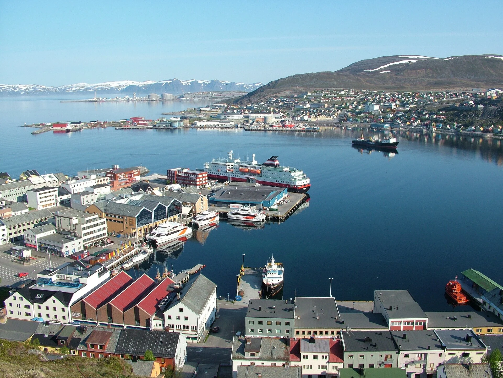 Blick von oben auf das Zentrum und den Hafen von Hammerfest mit Hurtigruten-Schiff am Kai.