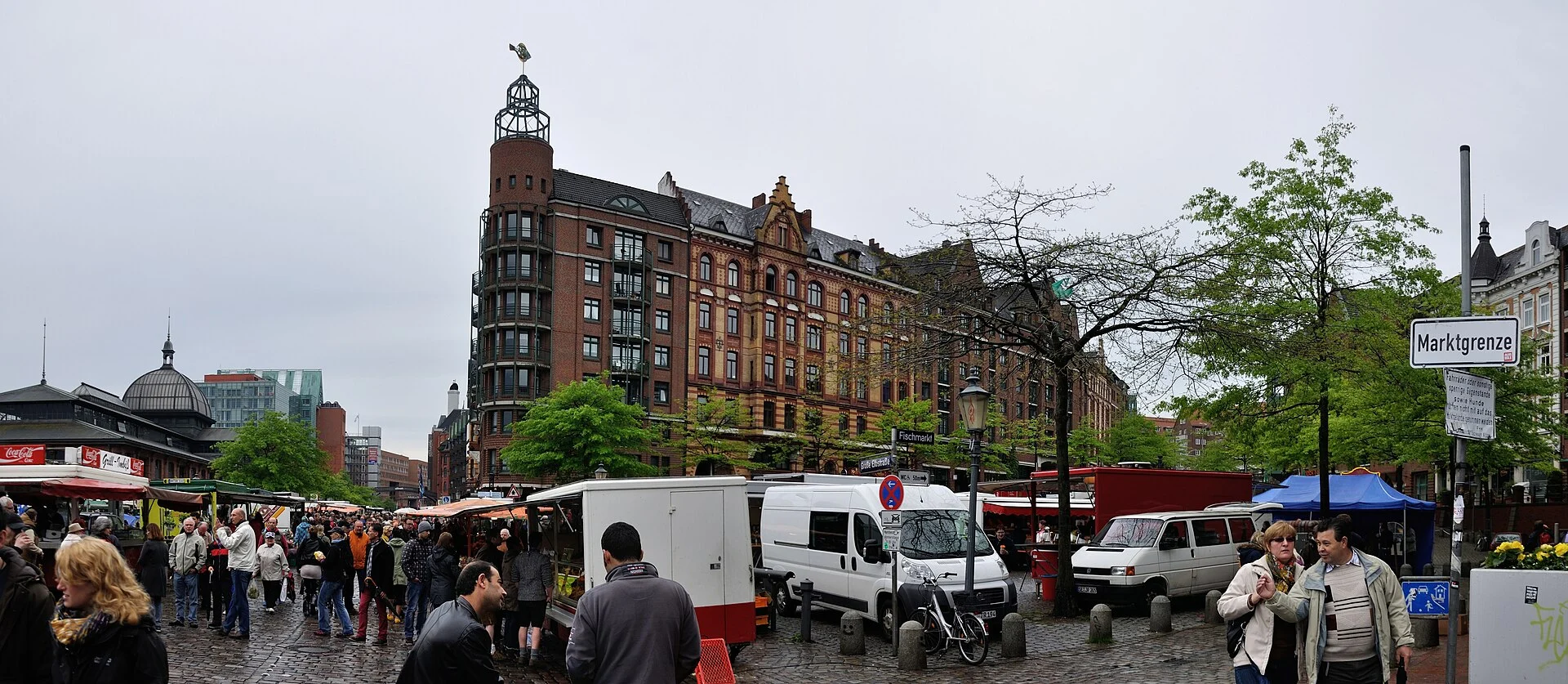 Sonntagmorgen auf dem Hamburger Fischmarkt mit Marktständen, Kuppel der Fischauktionshalle links und Schild „Marktgrenze“.