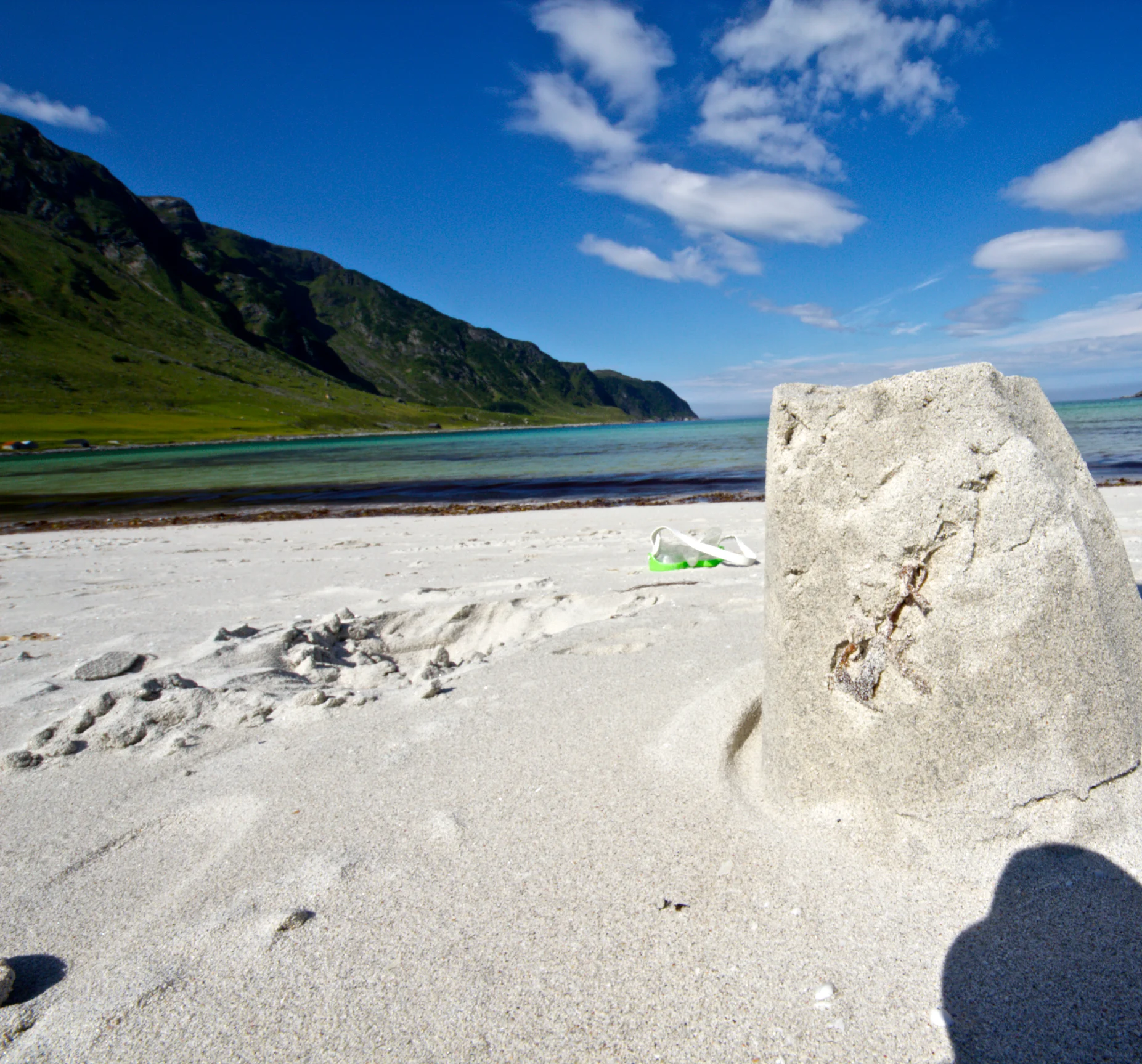 Der weiße Sandstrand Refviksanden mit türkisem Wasser und Bergen im Hintergrund