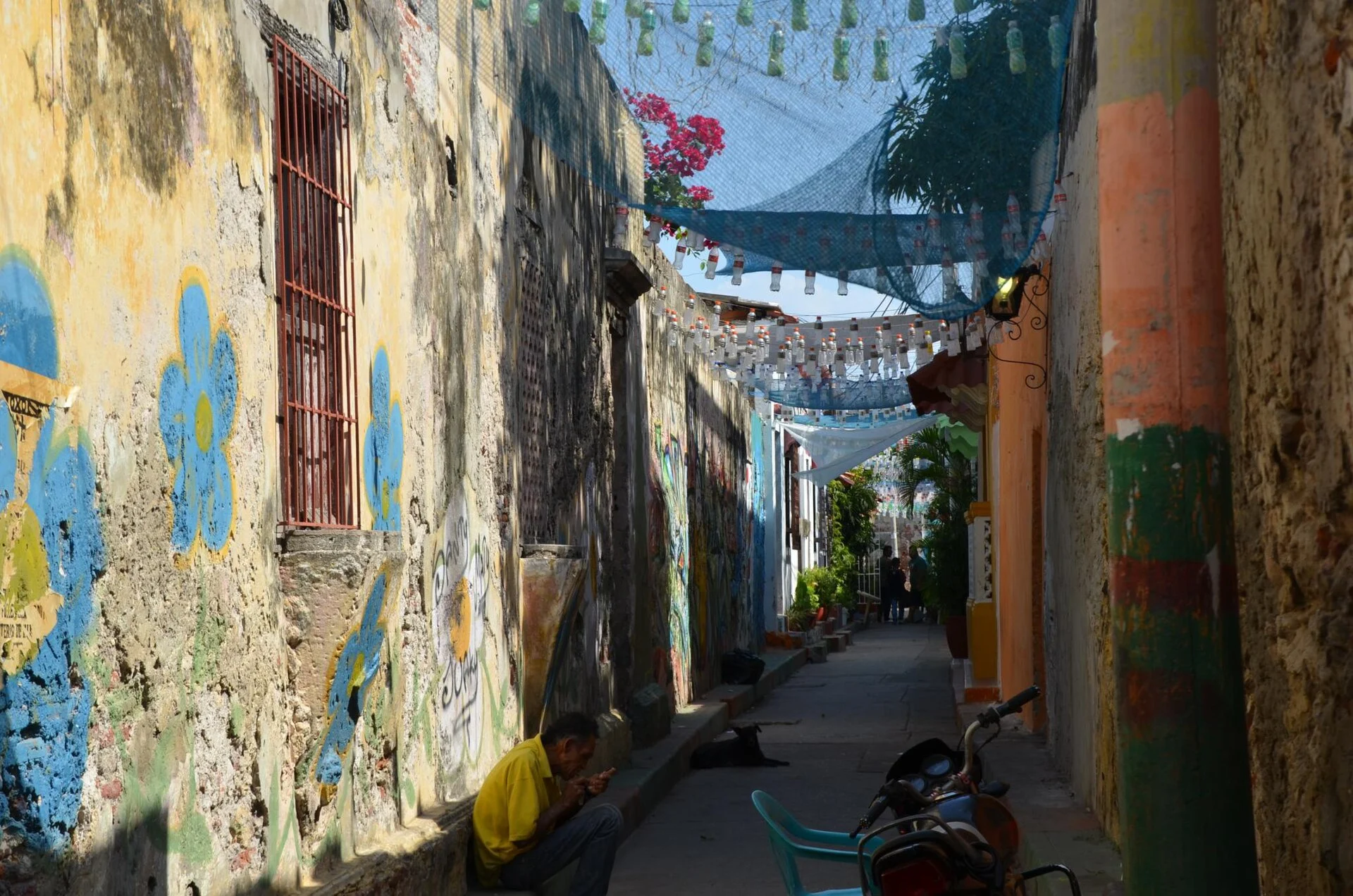 Eine Gasse in Getsemaní mit Wandbild und Fähnchen