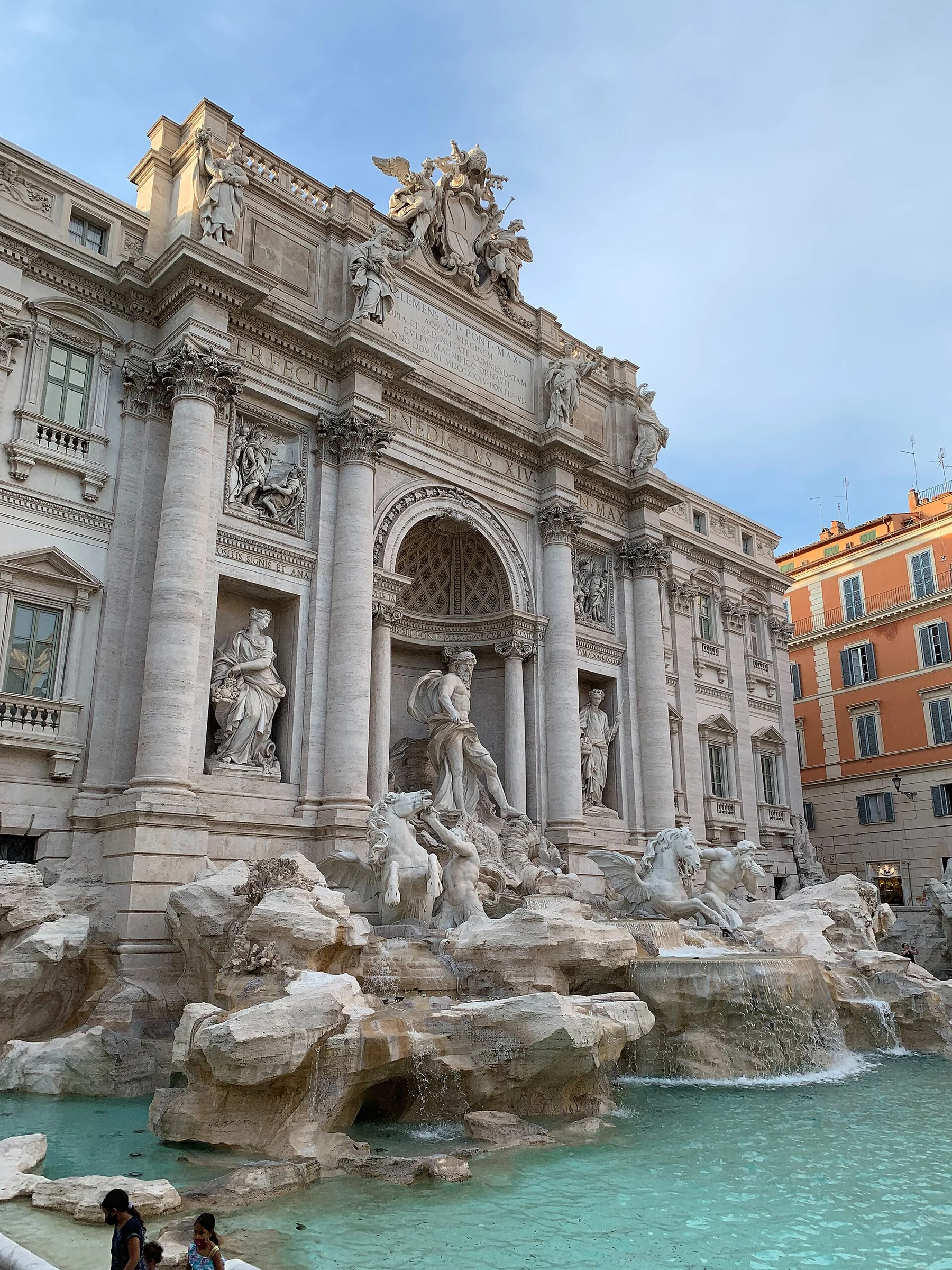 Der Trevi-Brunnen in Rom mit türkisfarbenem Becken und Skulpturengruppe vor dem Palazzo Poli am Abend.
