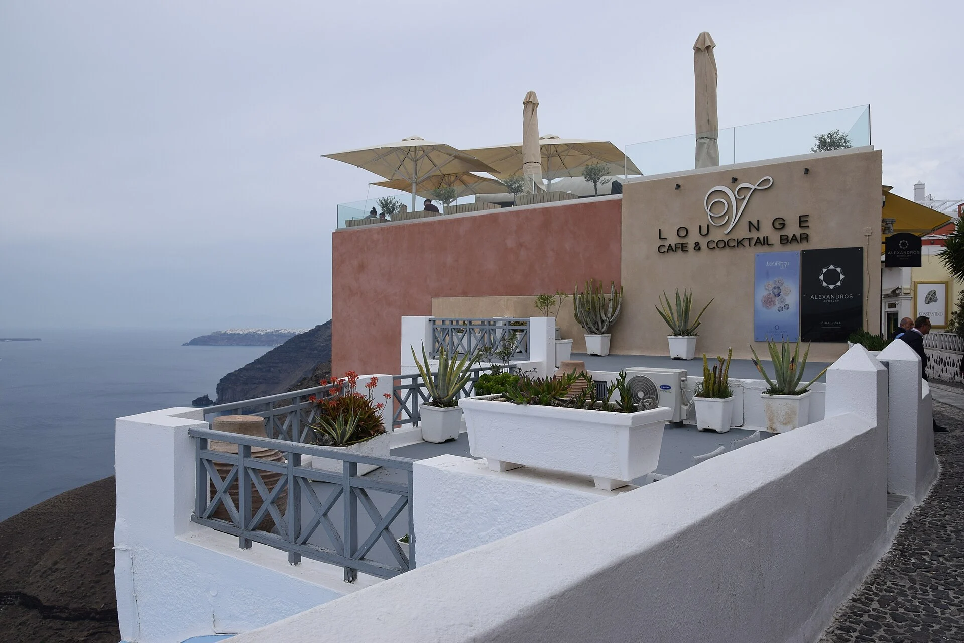 Terrassen-Café an der Calderakante von Fira auf Santorin mit Blick über das Meer.
