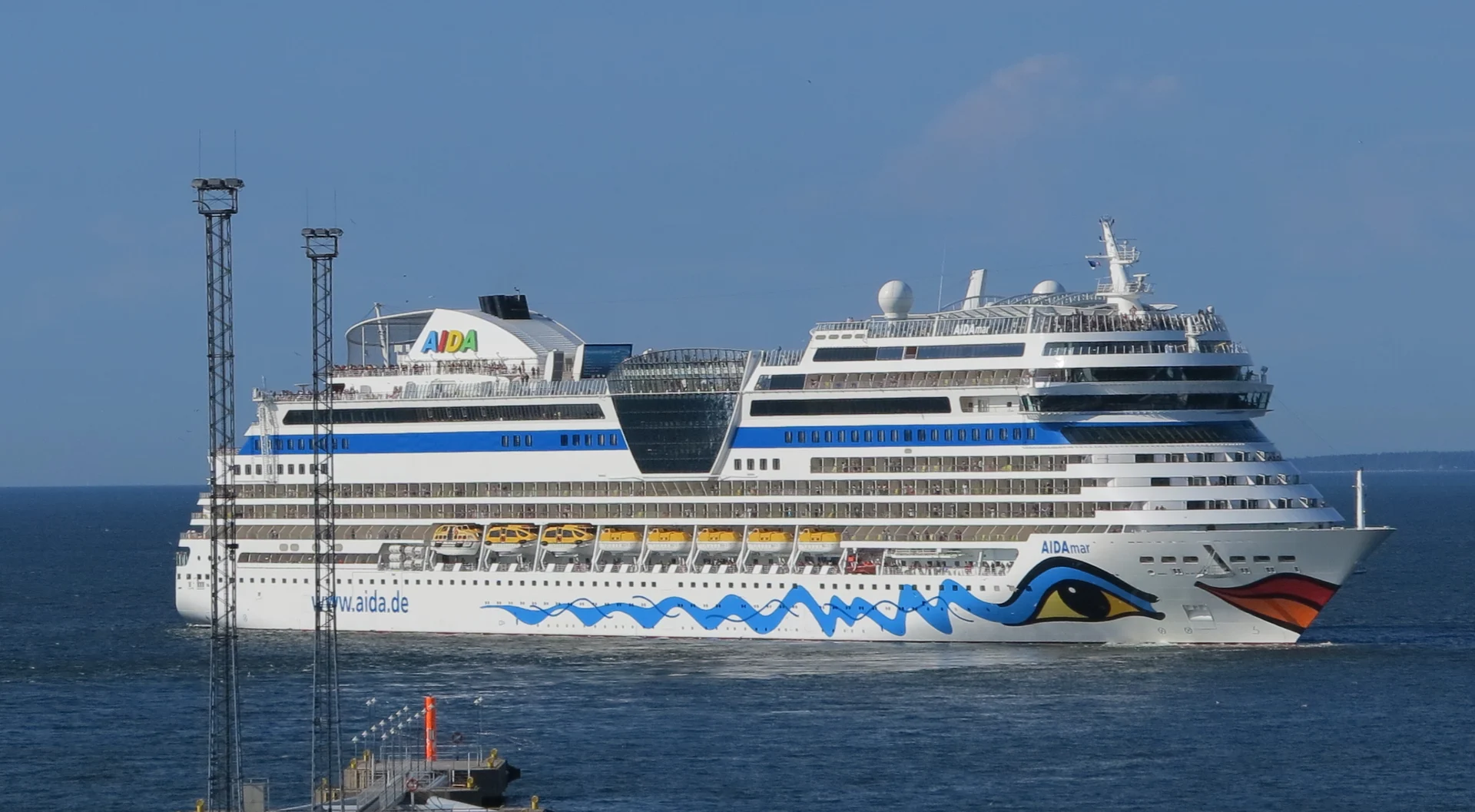 Die AIDAmar läuft bei Sonnenschein den Hafen von Tallinn an.