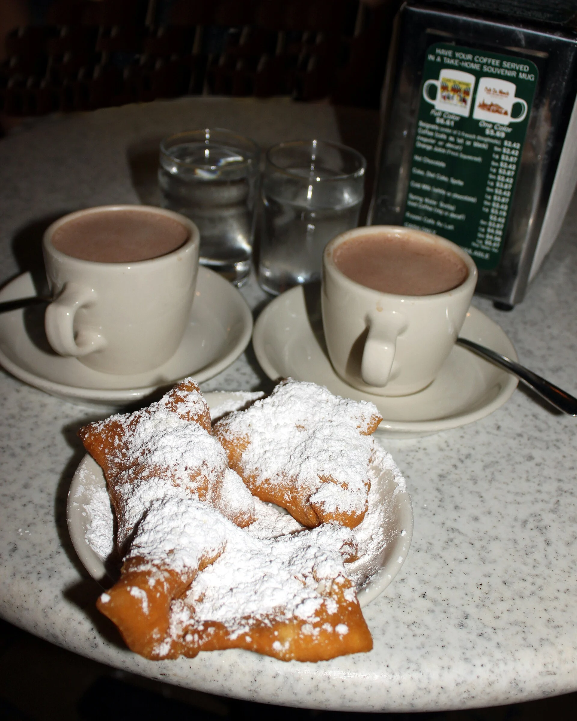 Beignets mit Puderzucker und Café au Lait