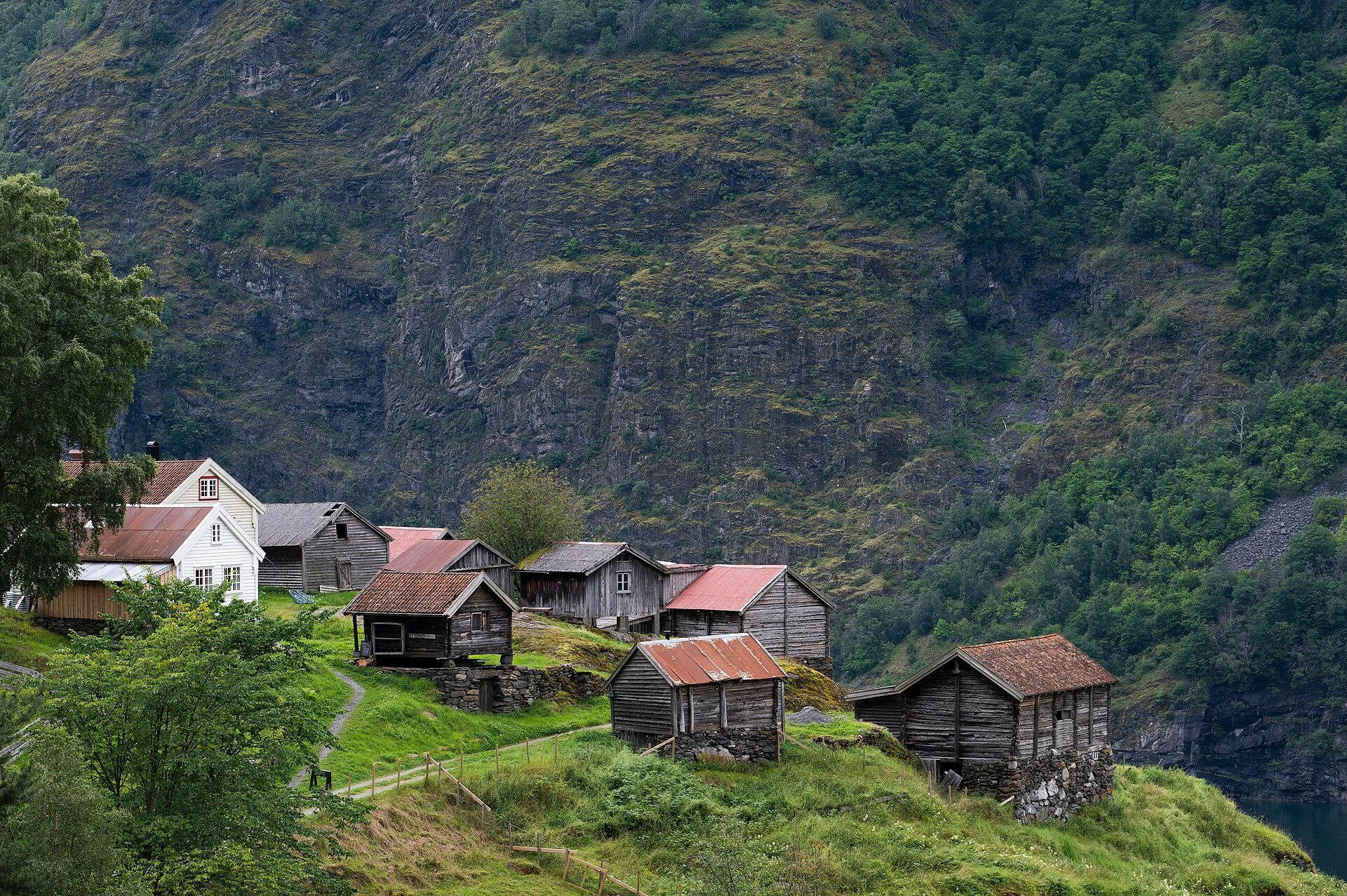 Gesamtansicht des historischen Bauernweilers Otternes Bygdetun auf einer Terrasse über dem Aurlandsfjord bei Flåm.