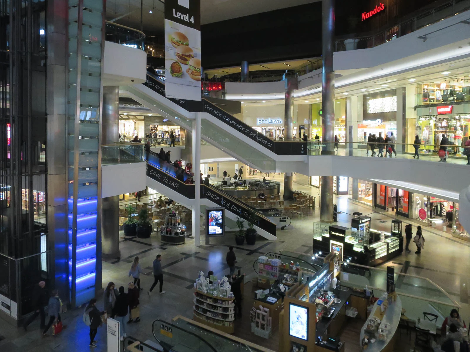Mehrgeschossige Halle mit Rolltreppen und Geschäften im Einkaufszentrum Westquay in Southampton.