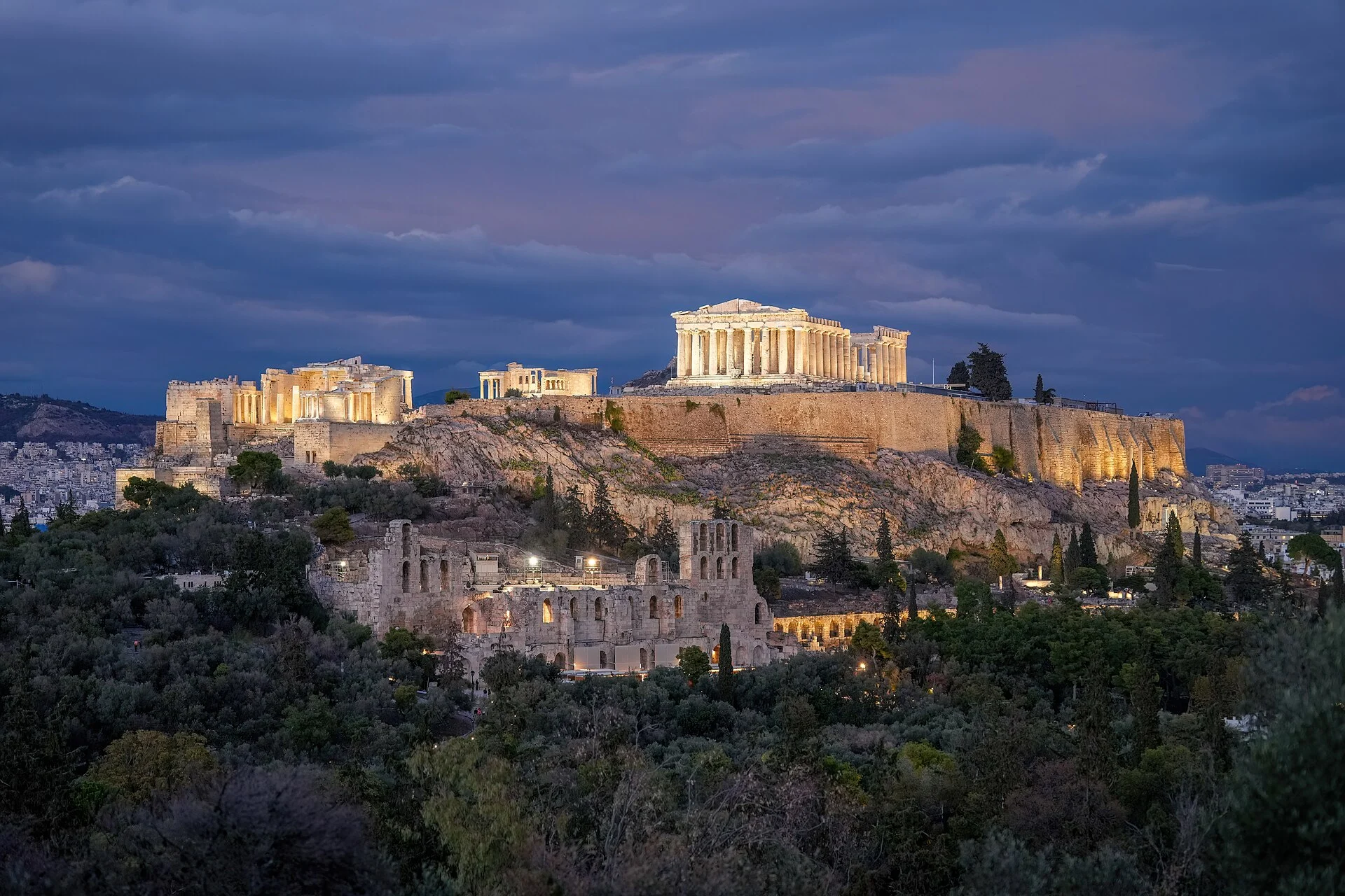 Die beleuchtete Akropolis von Athen mit Parthenon und Odeon des Herodes Atticus in der Abenddämmerung.