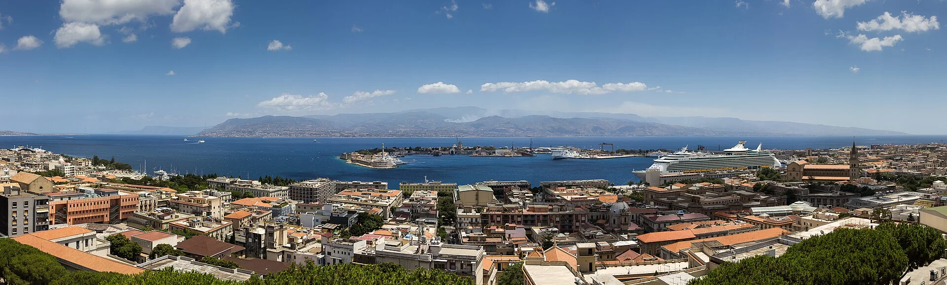 Messina mit dem sichelförmigen Hafen und der Meerenge, dahinter Kalabrien