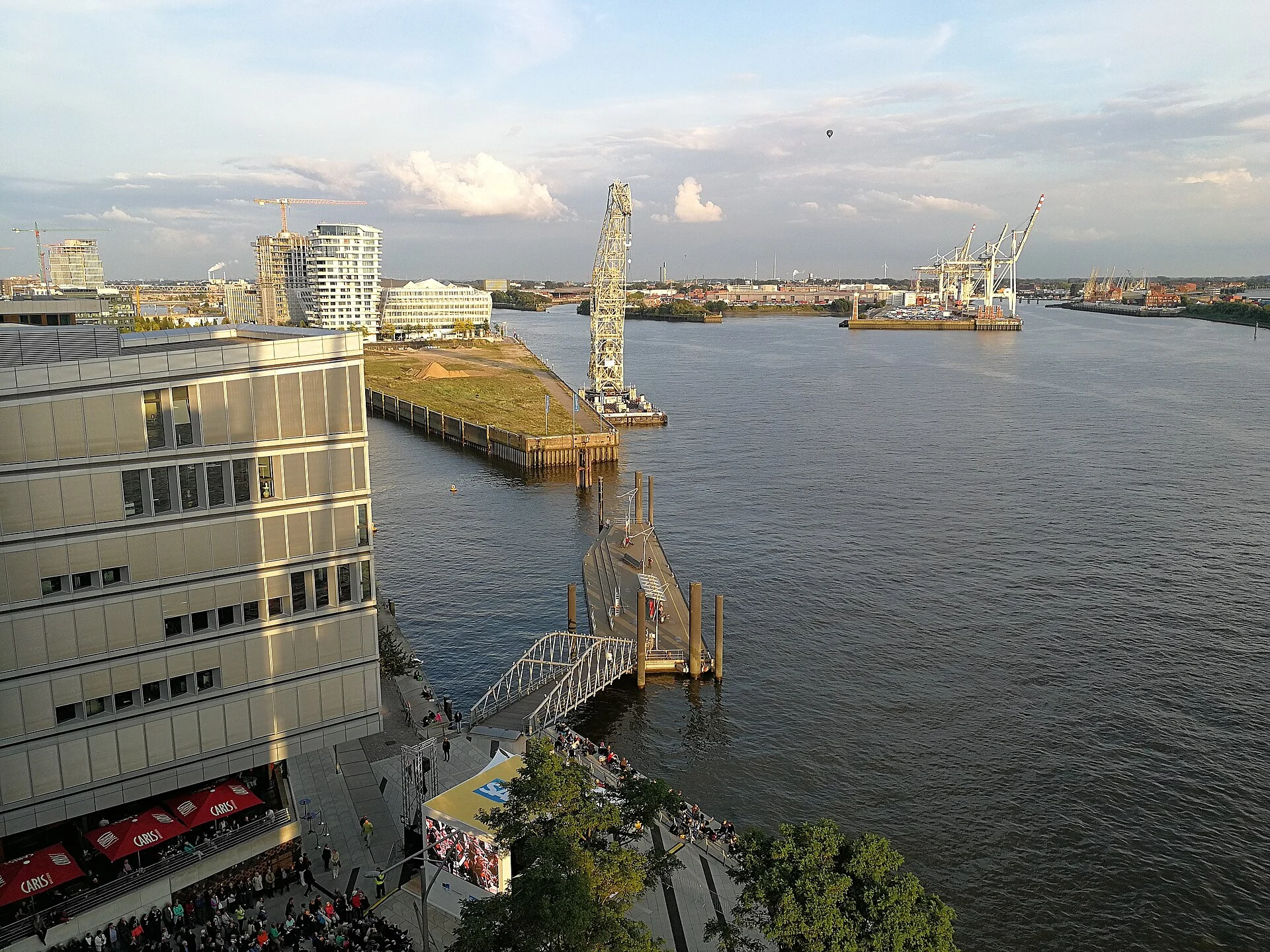 Blick von der Elbphilharmonie-Plaza über die Elbe auf die Hamburger HafenCity und die Hafenkräne am gegenüberliegenden Ufer.
