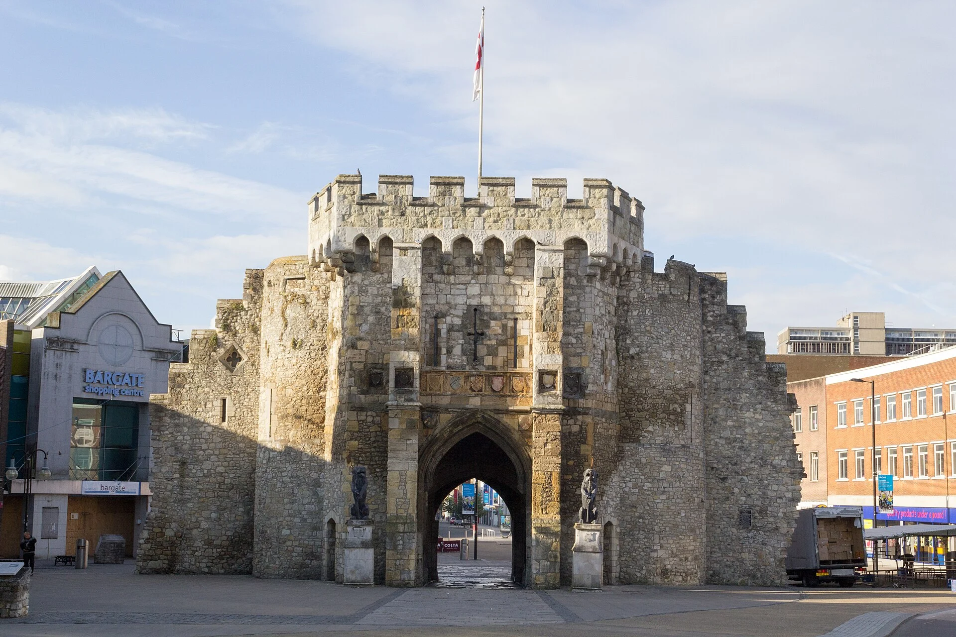 Das Bargate in Southampton in Frontalansicht bei Sonnenschein, links das Schild des Bargate Shopping Centre.