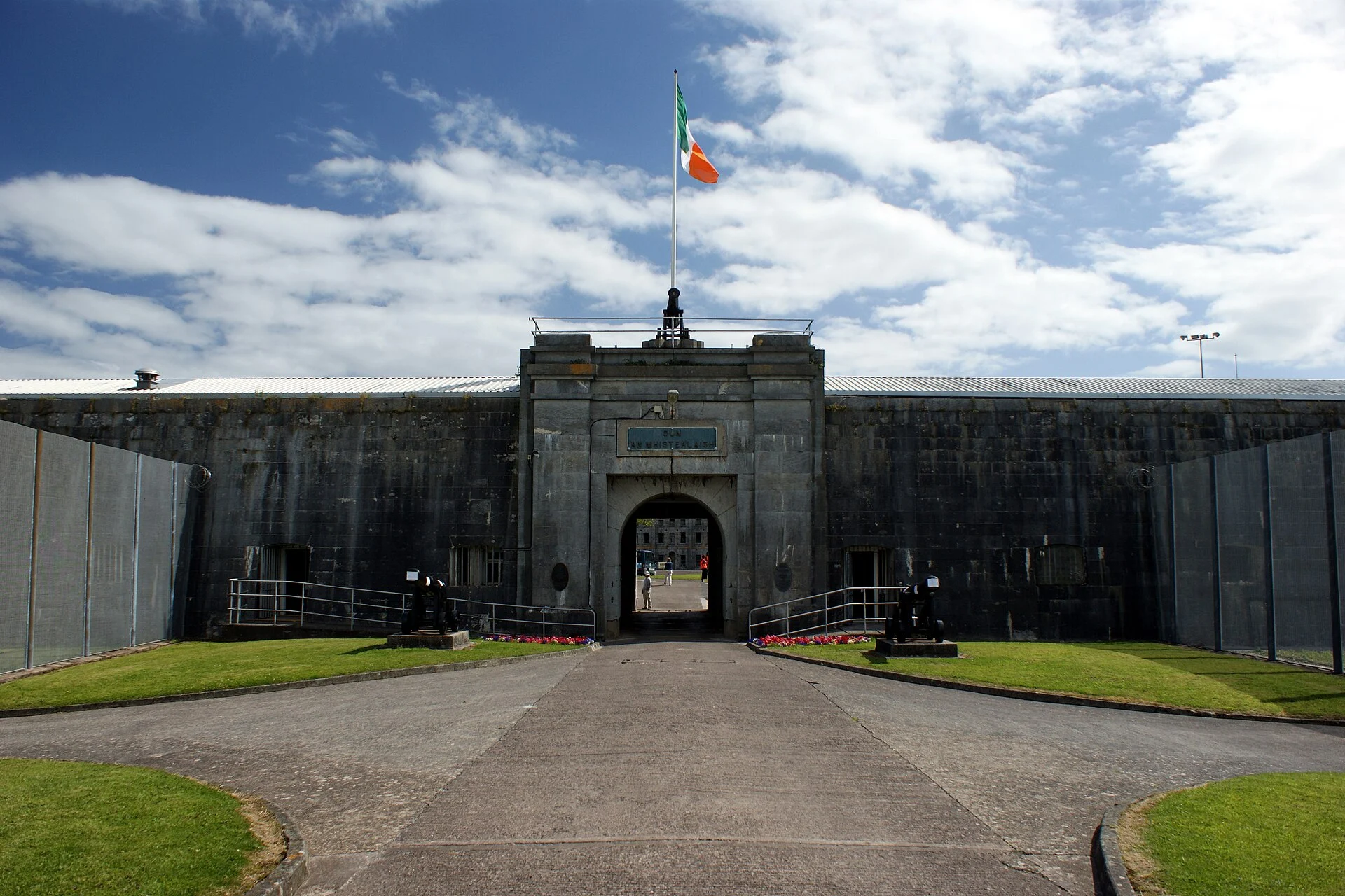 Torbau von Fort Mitchel auf Spike Island bei Cobh mit irischer Flagge und Kanonen am Zugangsweg.