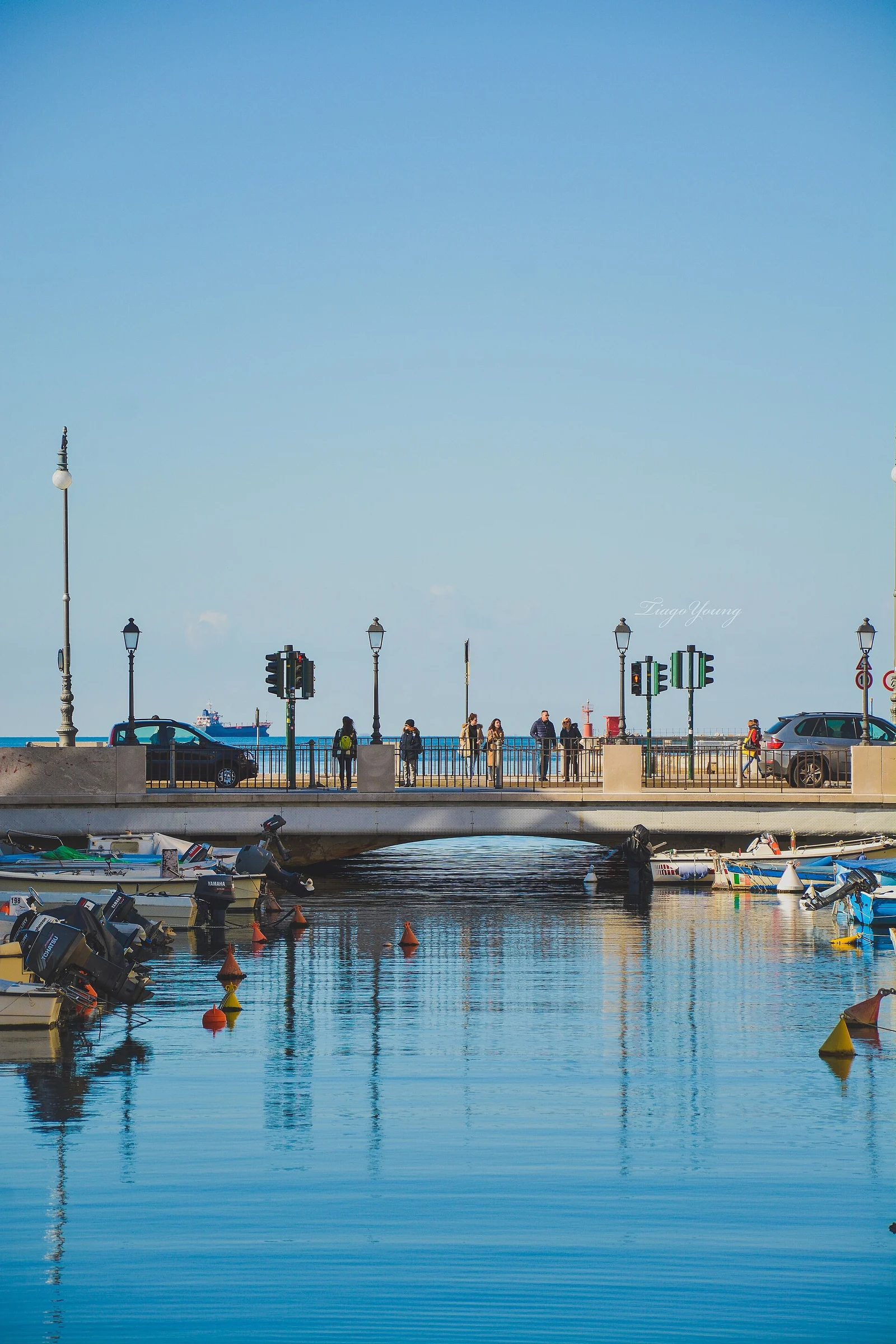 Blick über den Canal Grande in Triest mit Booten, Brücke und dem offenen Meer im Hintergrund.