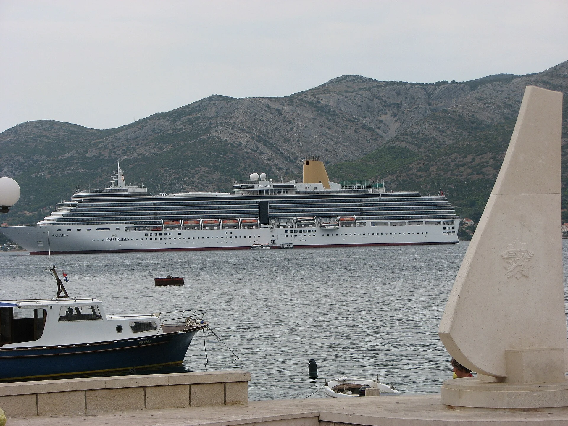 Ein Kreuzfahrtschiff auf Reede vor Korčula, davor die Stadtmauer