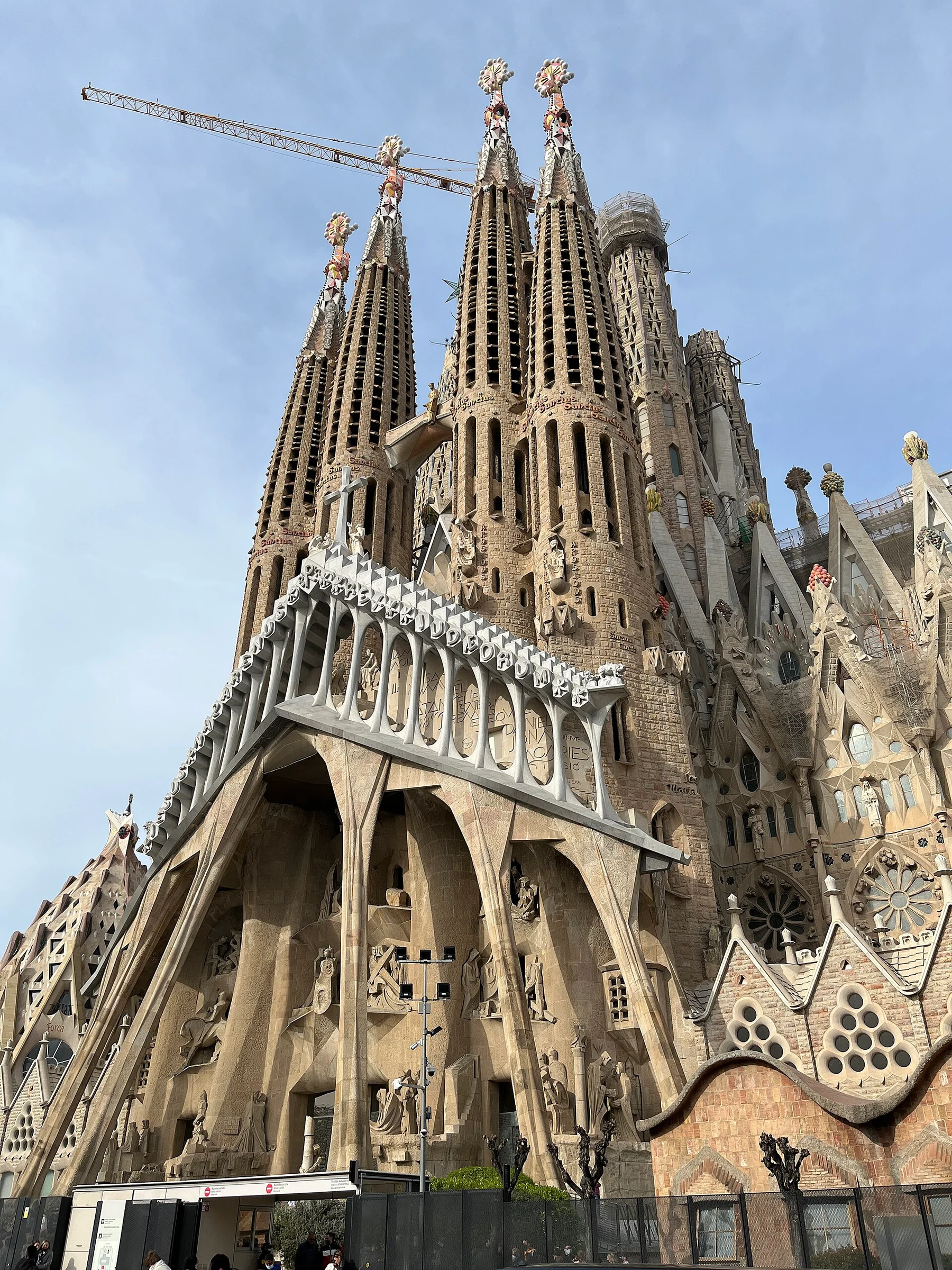 Die Passionsfassade der Sagrada Família in Barcelona mit vier Türmen und Baukran.