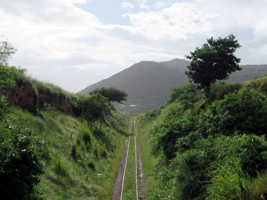 Die Gleise der St. Kitts Scenic Railway zwischen grünen Hängen