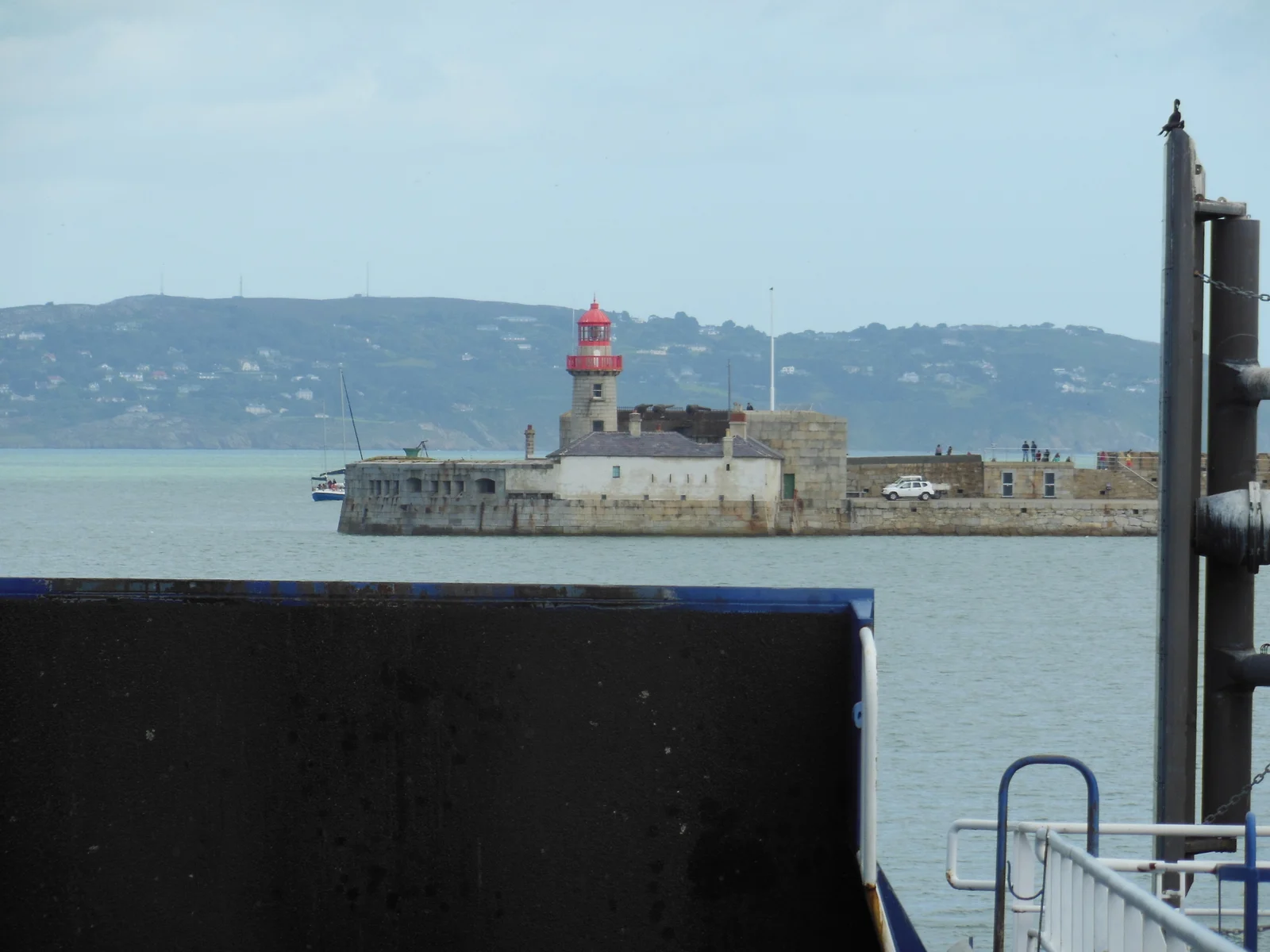 Der Leuchtturm am Kopf der East Pier in Dún Laoghaire mit der Halbinsel Howth im Hintergrund.