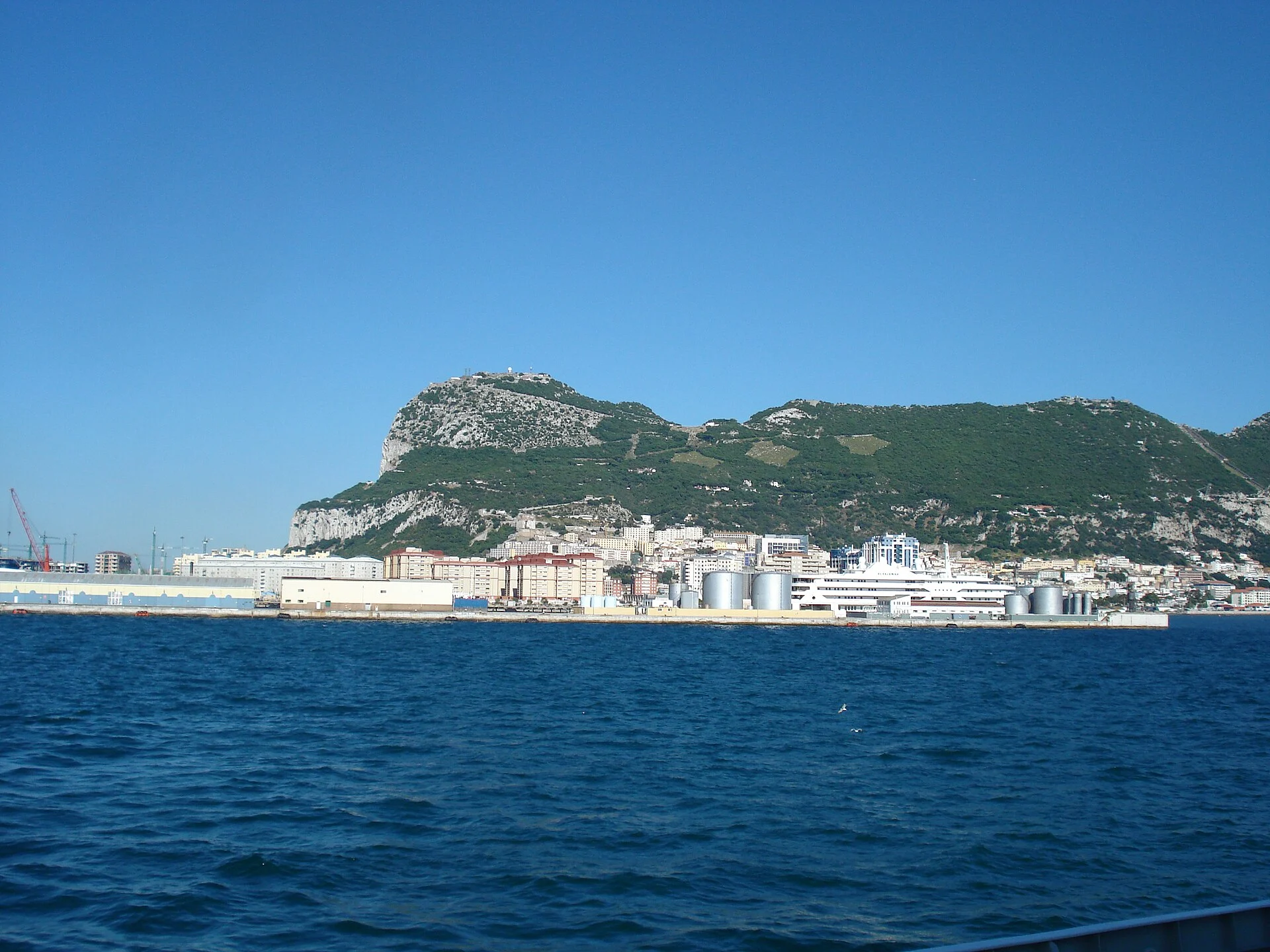 Der Felsen von Gibraltar vom Wasser aus, davor die Hafenanlagen und die Stadt