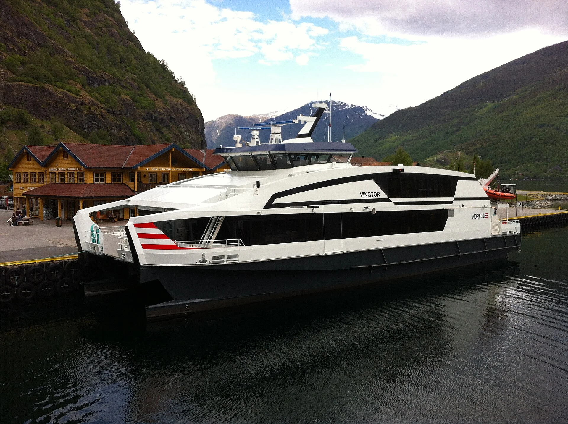 Das Fjordschnellboot „Vingtor“ am Anleger in Flåm vor den Bergen des Aurlandsfjords.