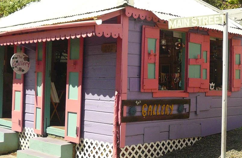 Ein Holzhaus in Rosa und Grün an der Main Street in Road Town auf Tortola