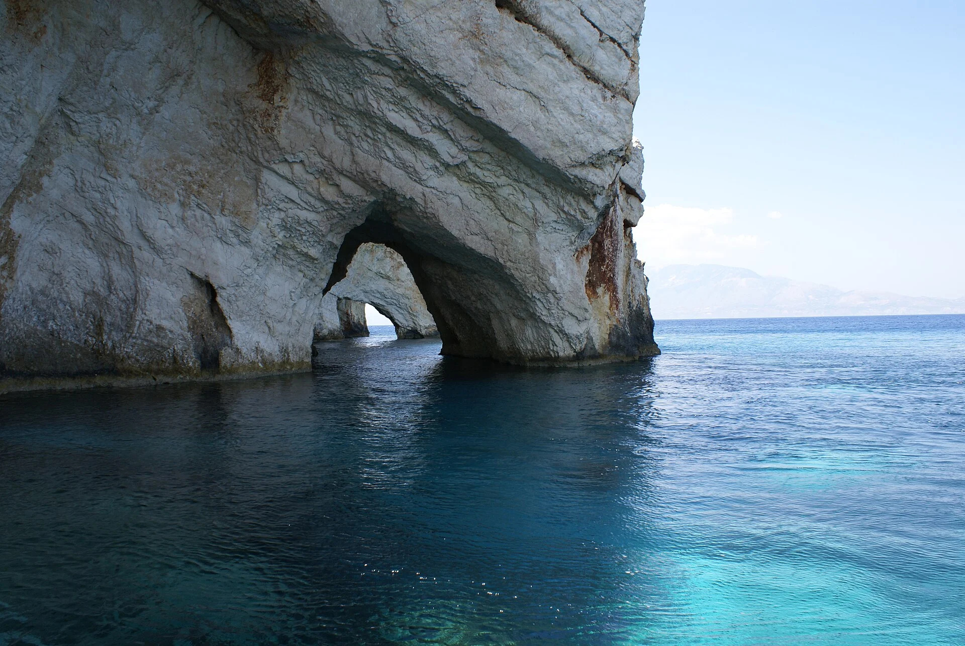 Ein Felsbogen der Blauen Grotten auf Zakynthos über türkisem Wasser