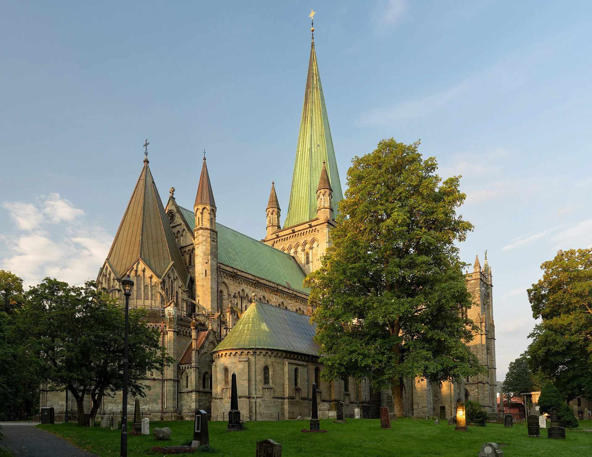 Der Nidarosdom in Trondheim mit Turm und Chor, umgeben von Bäumen