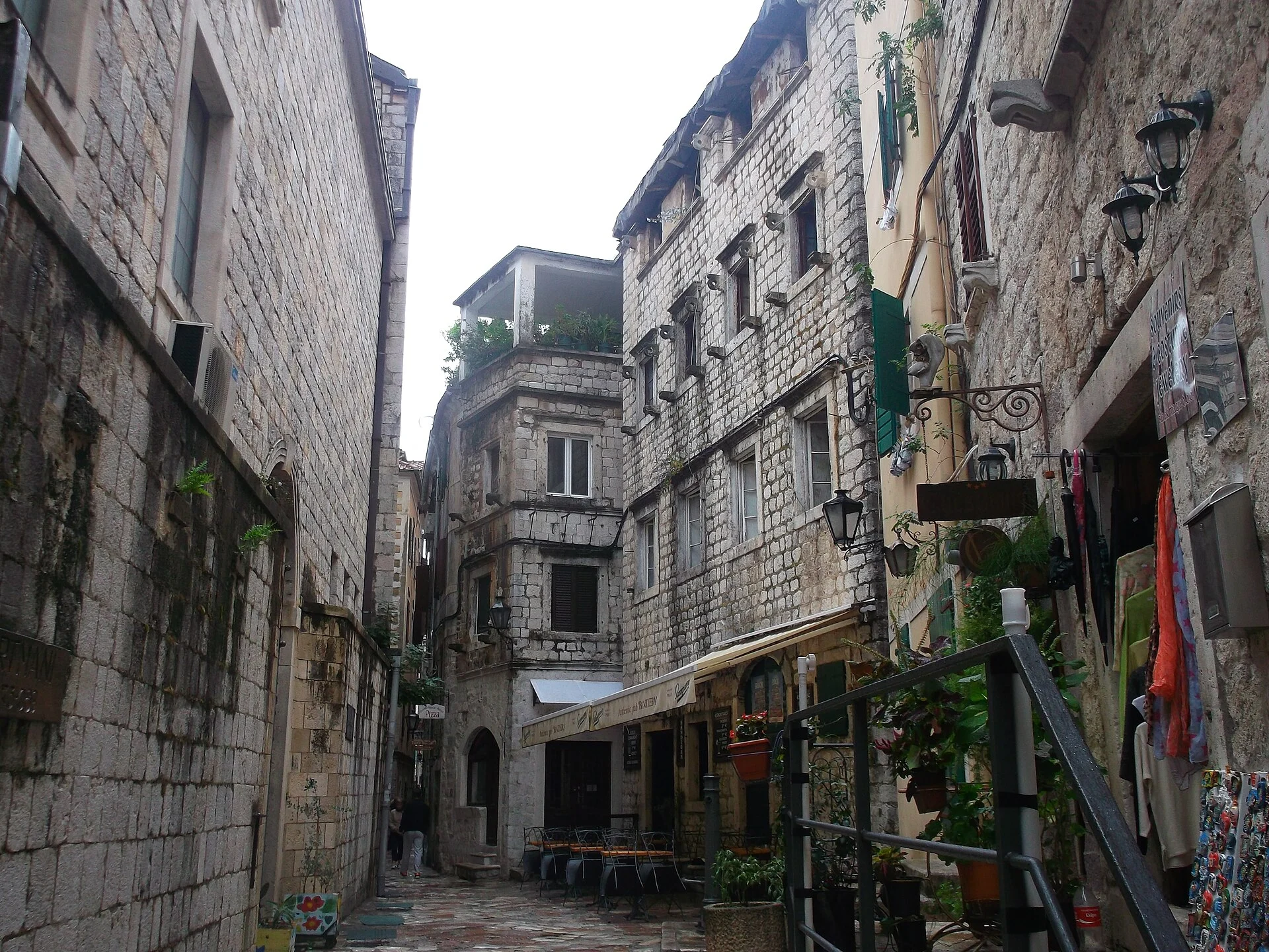 Verwinkelte Gasse mit Steinhäusern, Läden und Café in der Altstadt von Kotor.