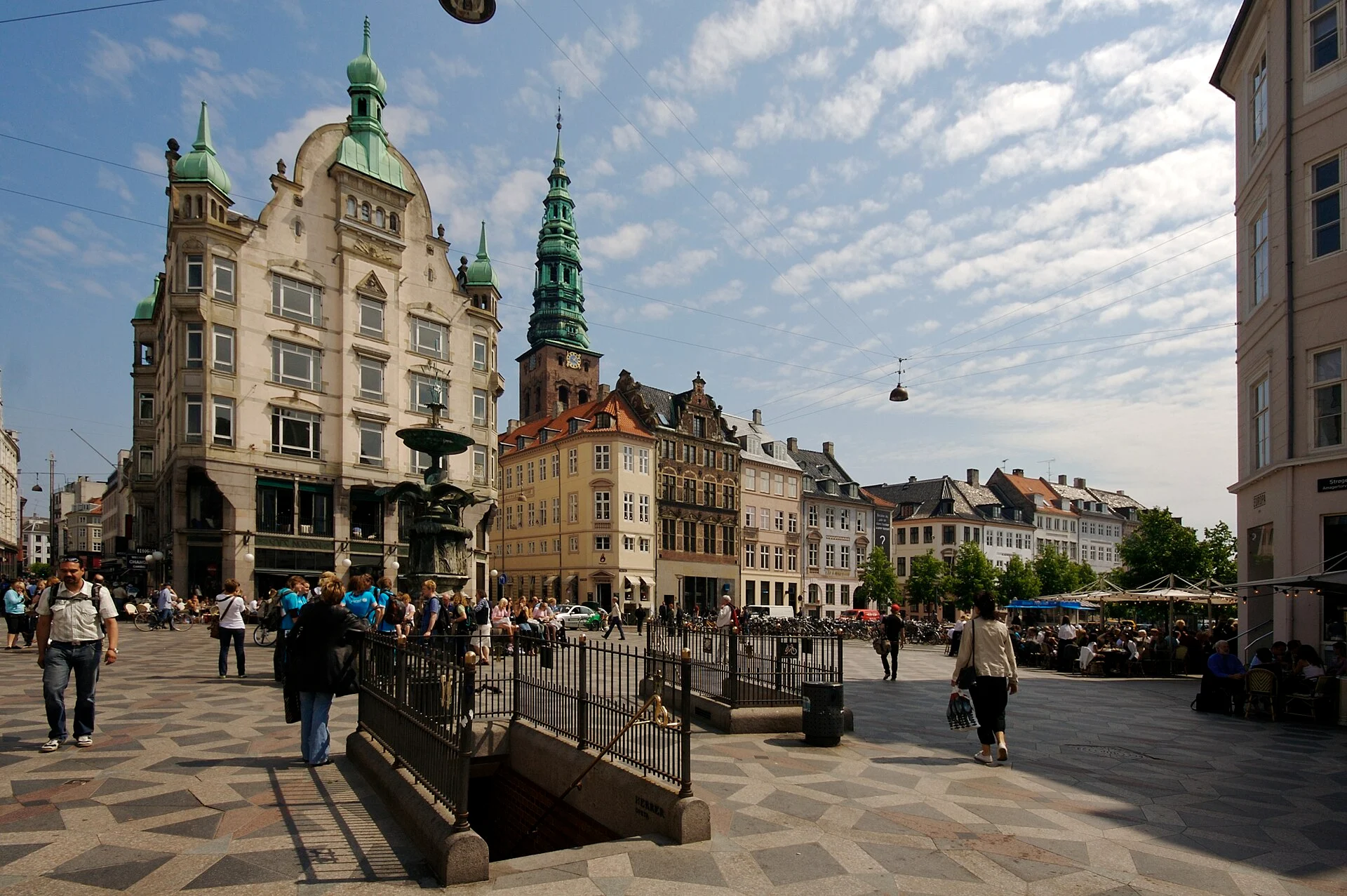 Amagertorv an der Fußgängerzone Strøget in Kopenhagen mit Storchenbrunnen und dem Turm der Nikolaikirche im Hintergrund.