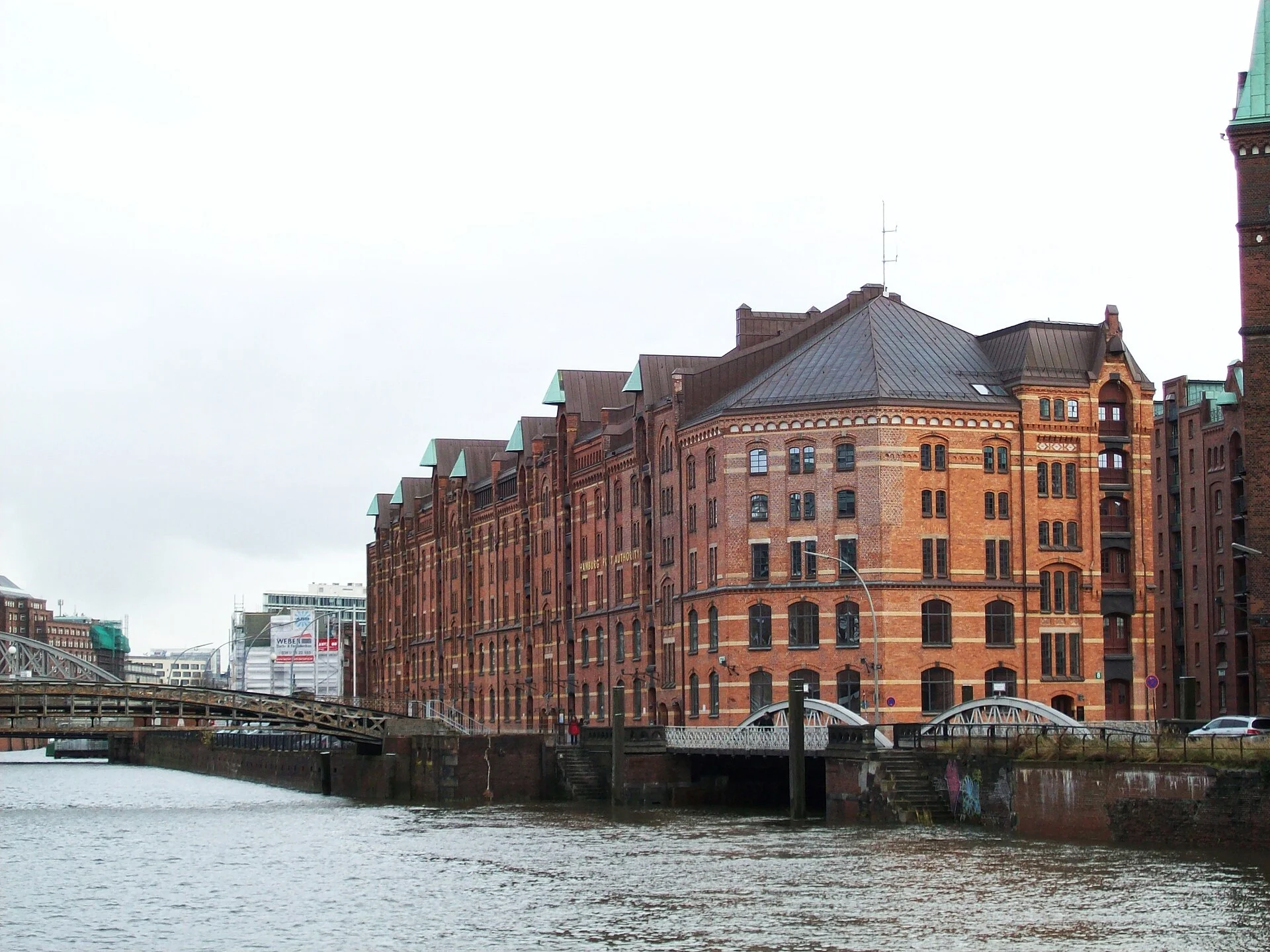 Speicherzeile der Hamburger Speicherstadt mit Rundgiebel, Brücken und Fleet im Vordergrund.
