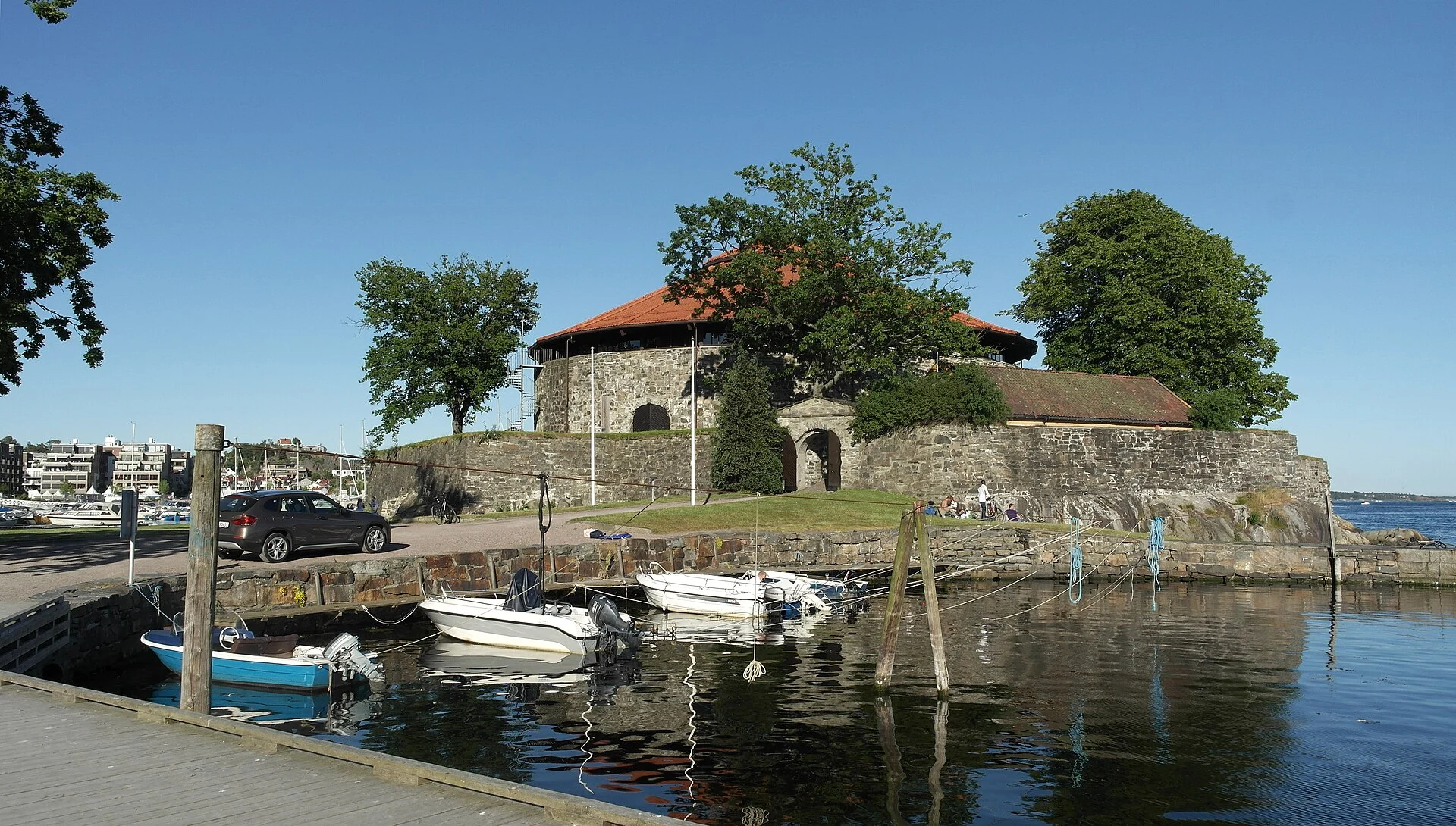 Die Festung Christiansholm auf ihrer Landzunge am Hafen von Kristiansand, davor Boote am Kai.