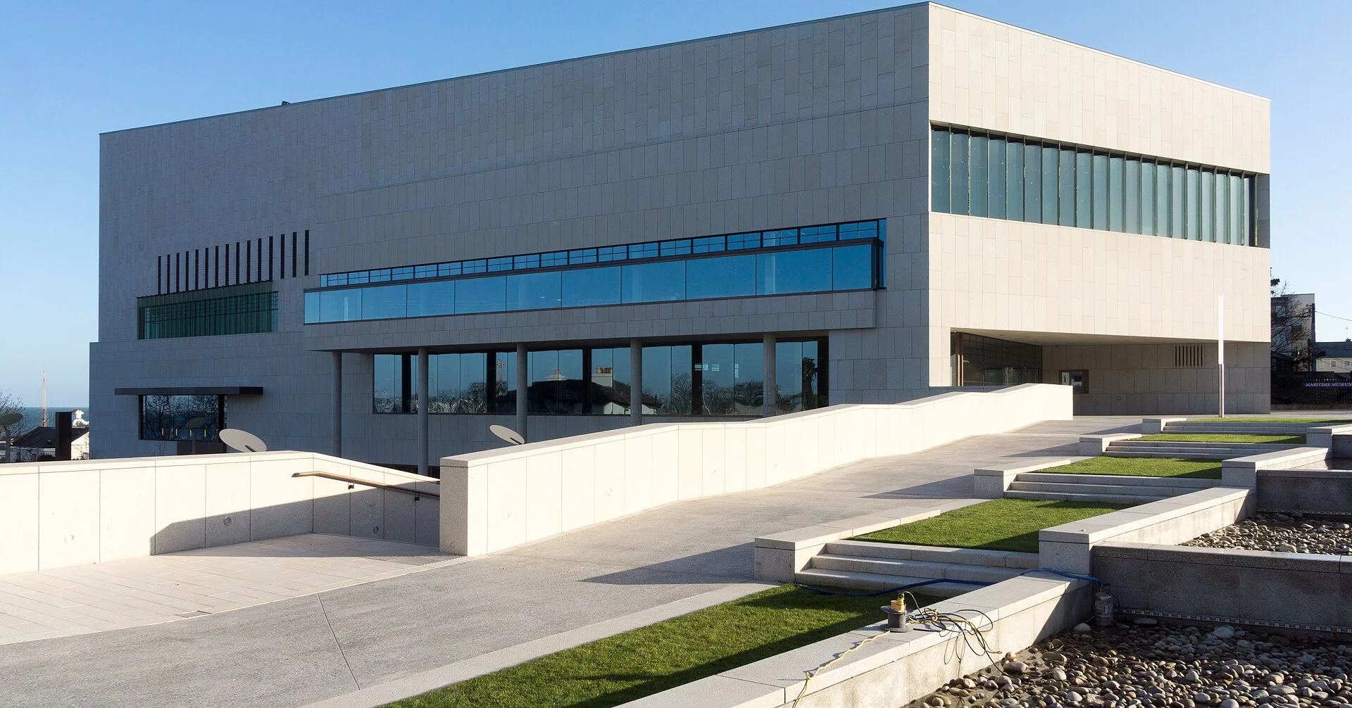 Das dlr LexIcon in Dún Laoghaire mit heller Kalksteinfassade, Vorplatz und Rampen im Moran Park.