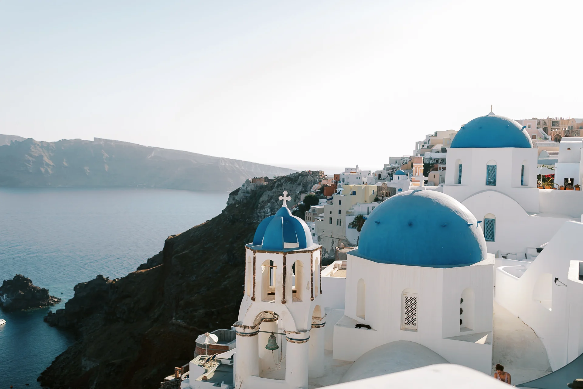 Die berühmten blauen Kuppelkirchen von Oía auf Santorin oberhalb der Caldera-Steilküste.