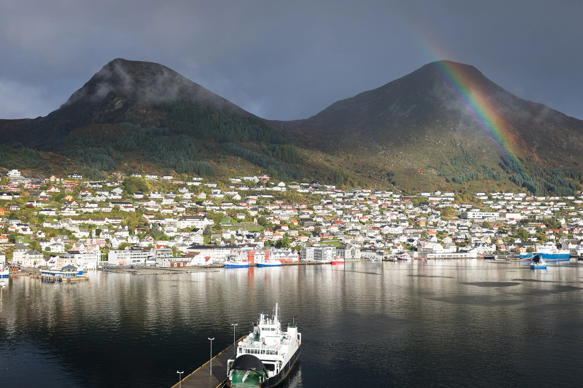 Der Ort Måløy am Ulvesundet mit Hafen, Schiffen und den Bergen dahinter